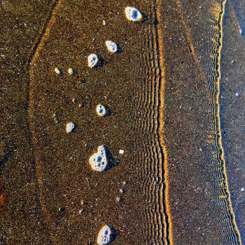 A series of tightly packed small waves rolling along the sand. A metaphor for life-energy bringing forth miracles.