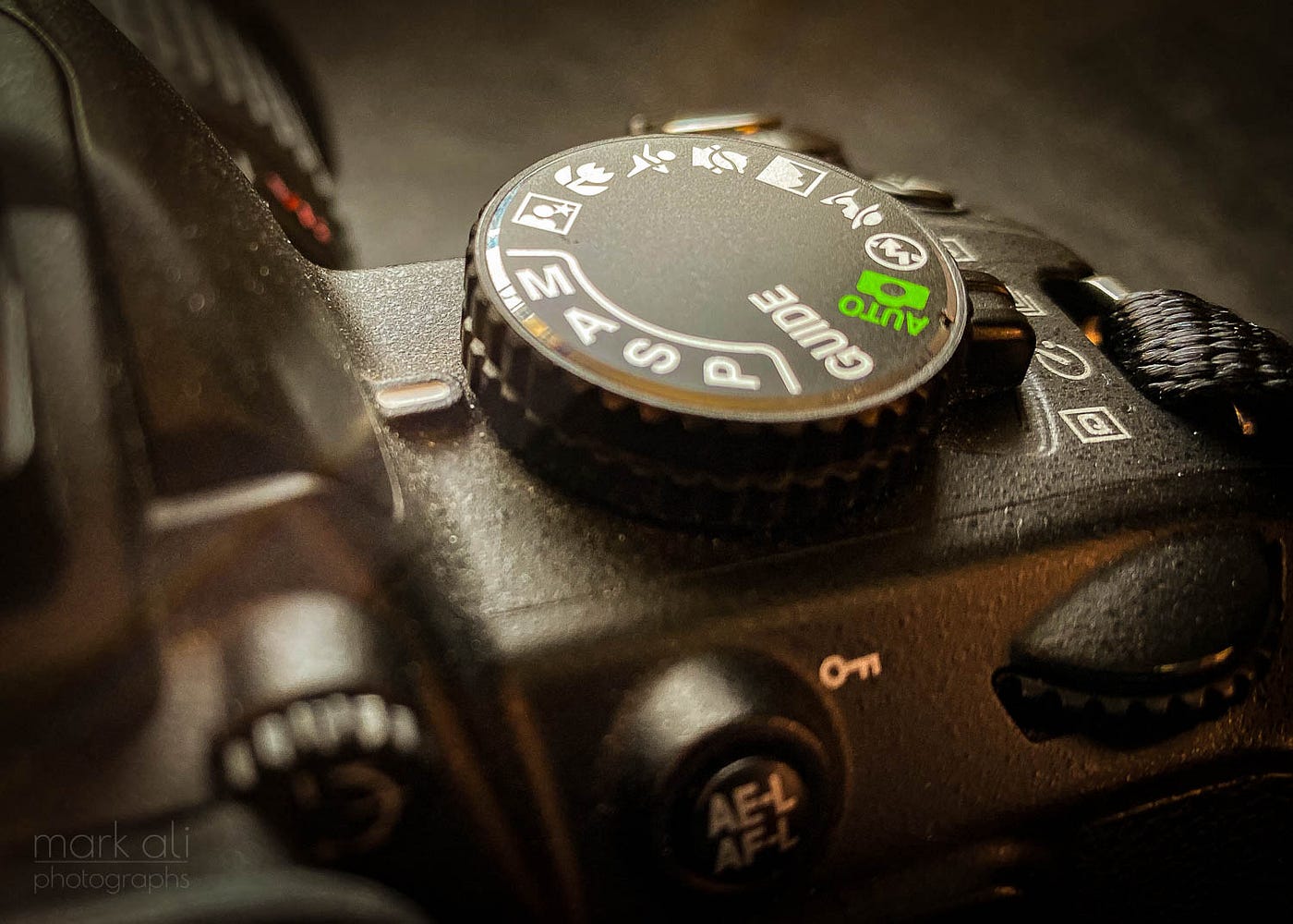 A close-up of the mode dial on a camera.