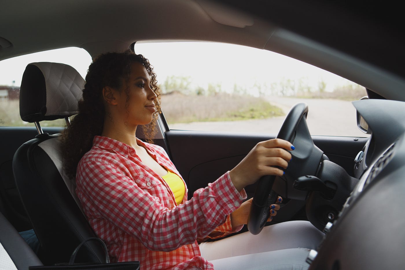 Woman driving with both hands on the wheel.