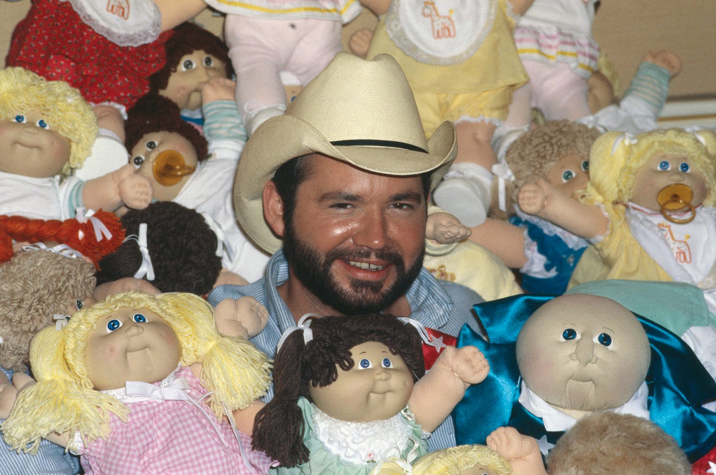 Xavier Roberts sits in a pile of the Cabbage Patch Dolls that he created. 