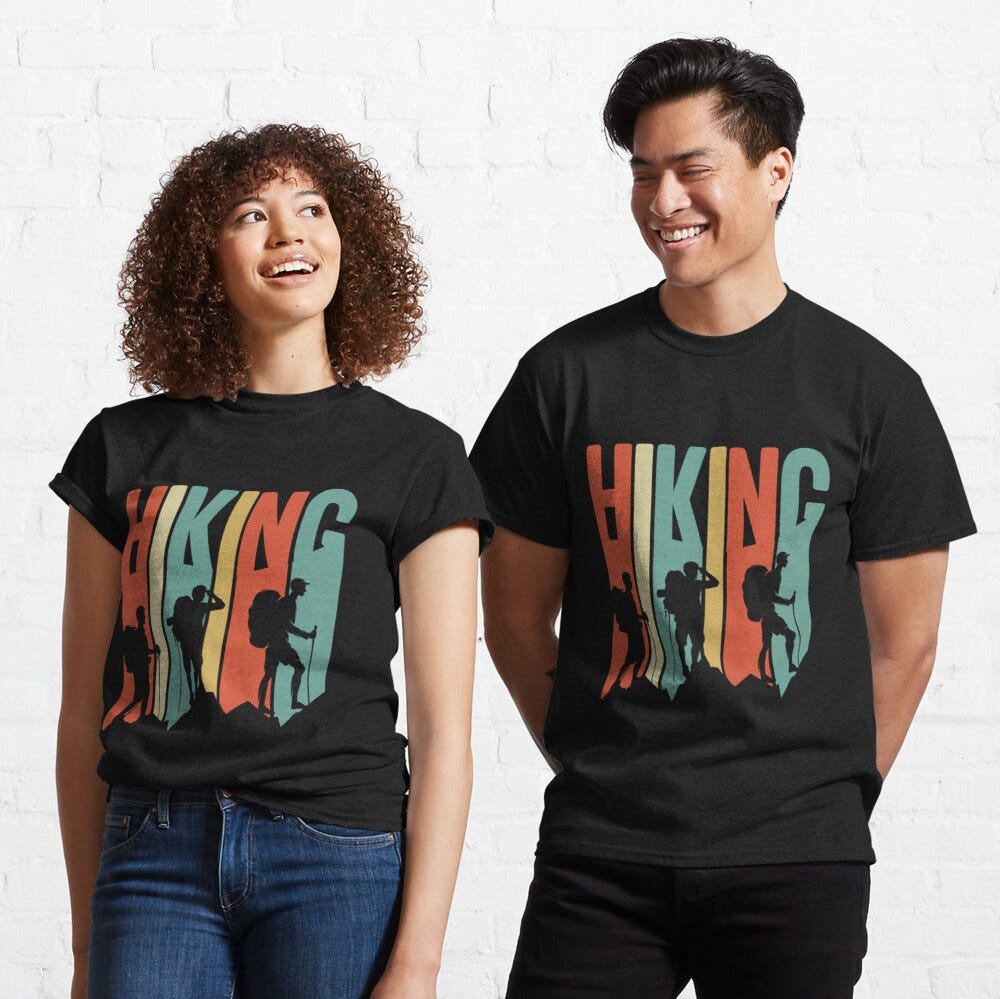 Man and Women wearing a black classic t-shirt with amazing illustration and text saying “hiking”.