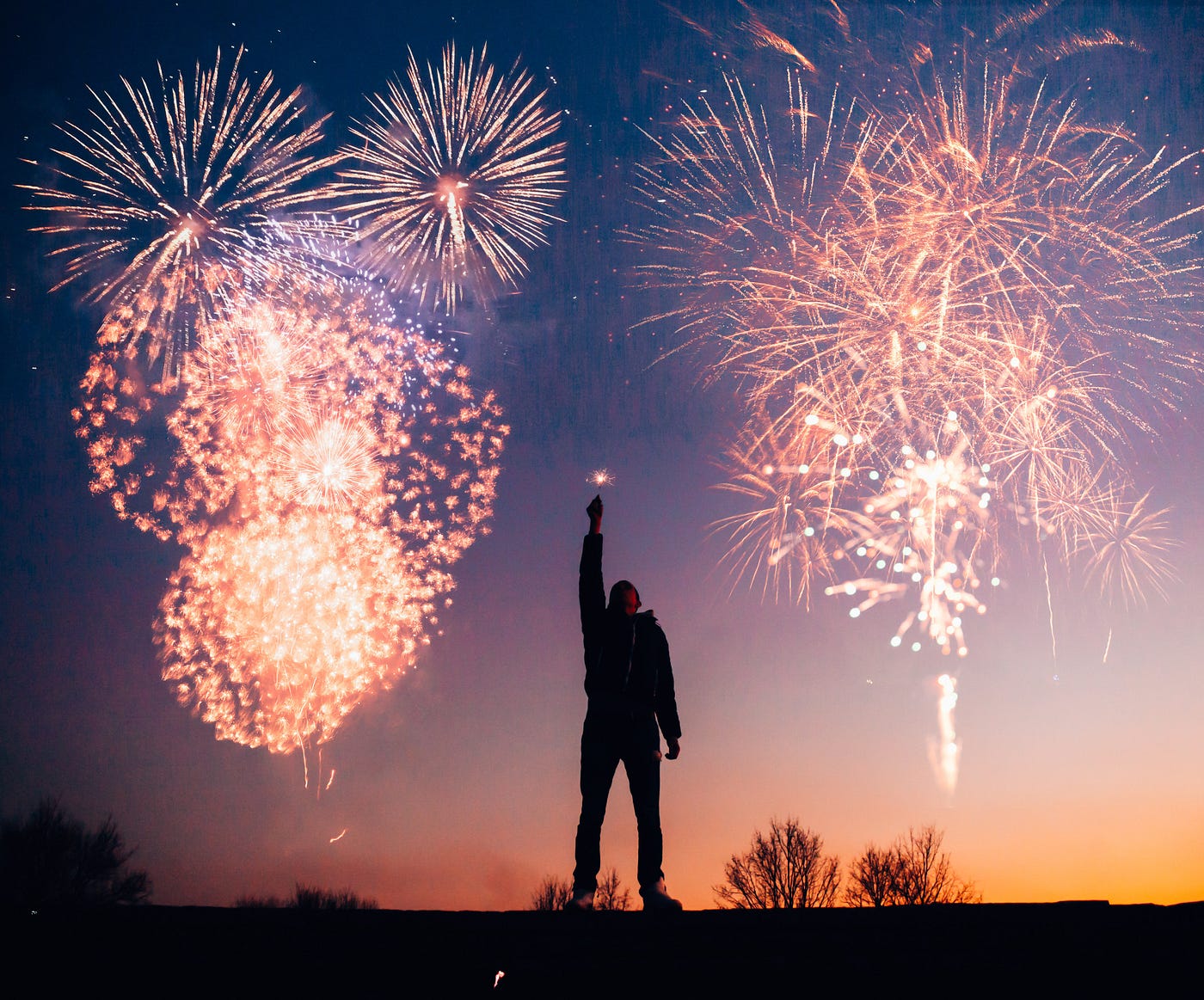 Silhoute of a man with fireworks in the background.