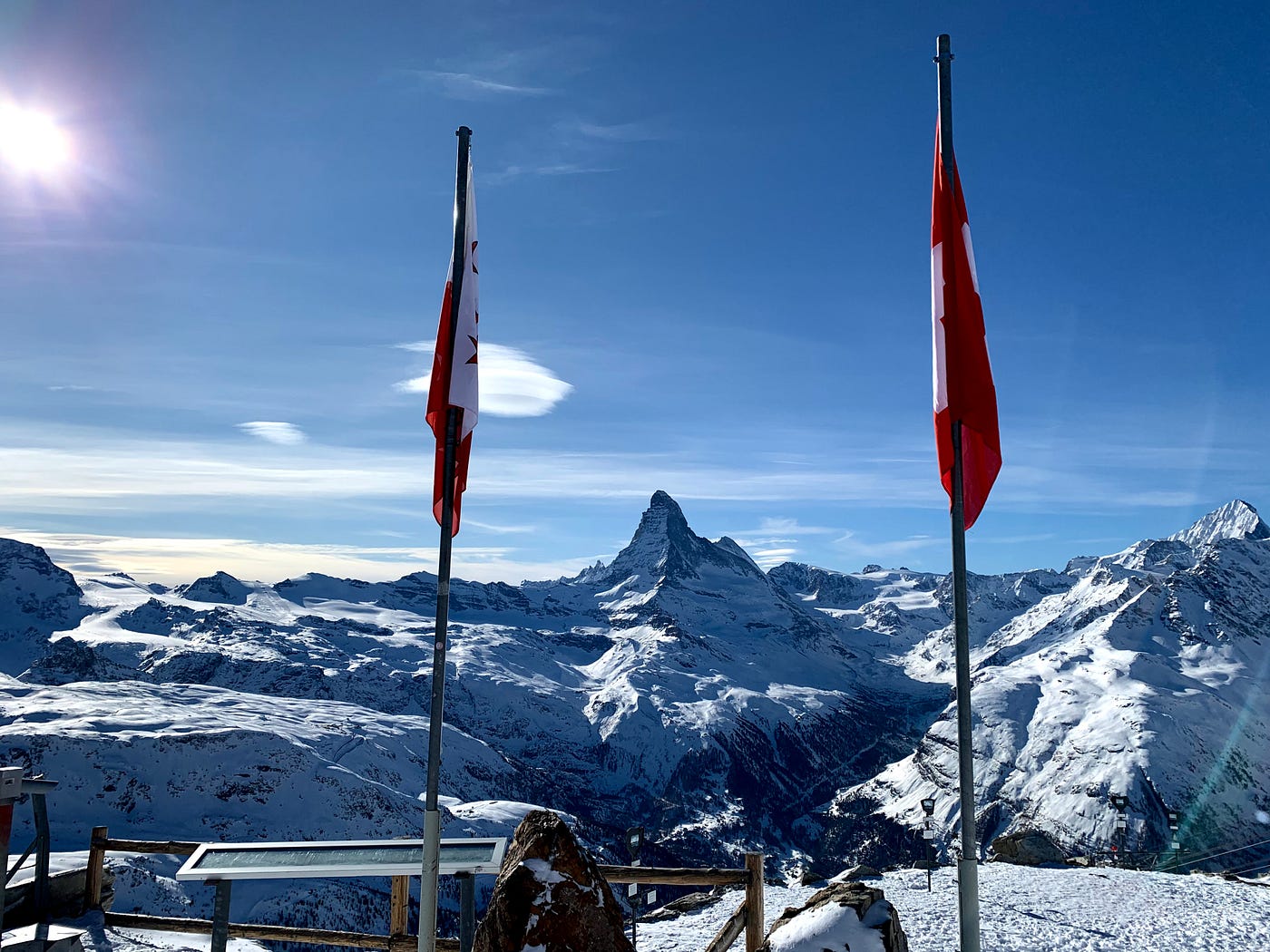 The Matterhorn in between a Valais canton flag and a Swiss flag