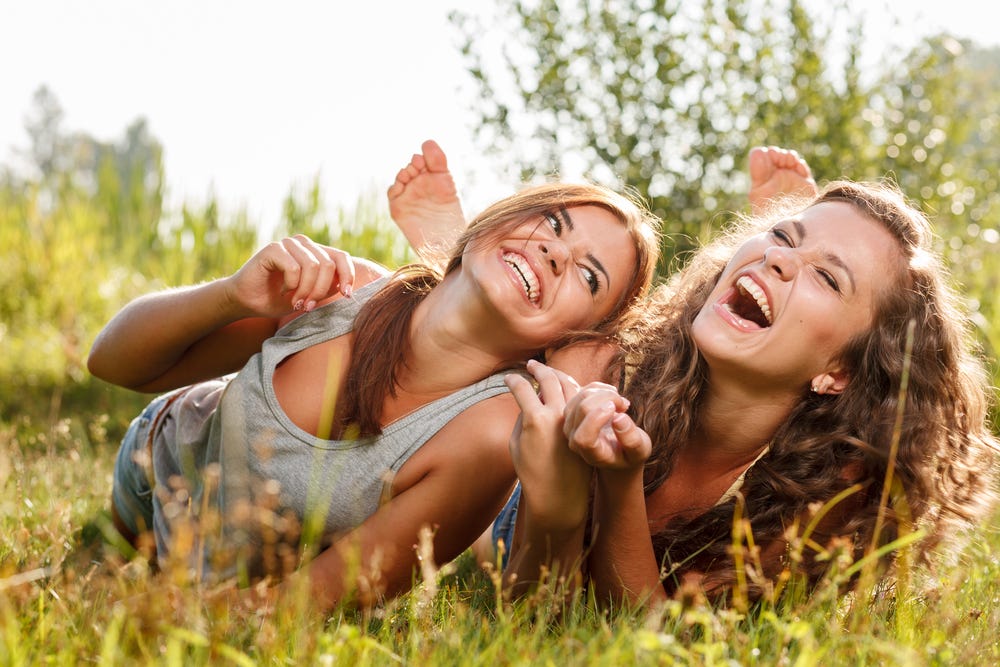 Two women laughing together.