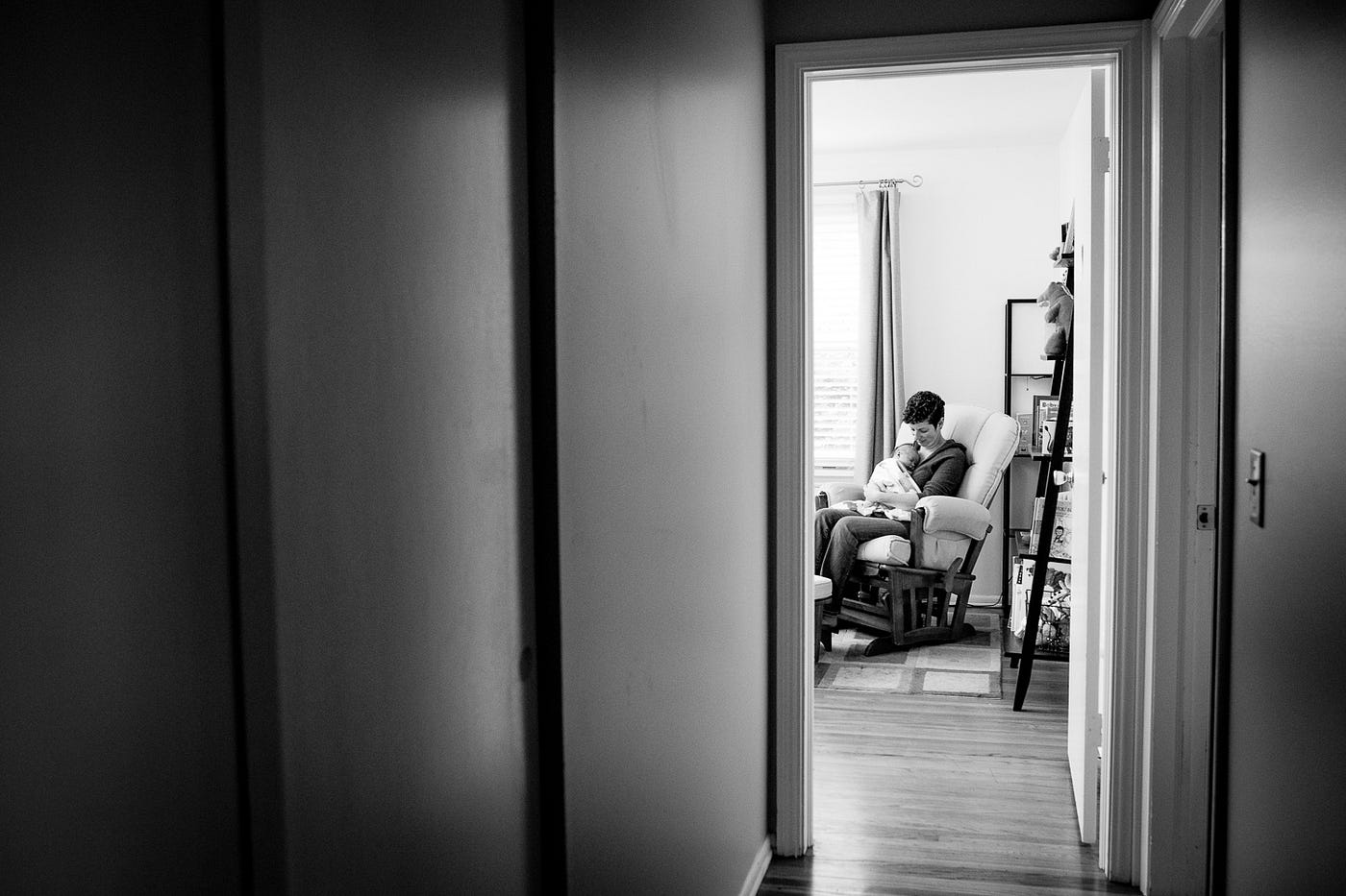 looking down a hallway to a mother rocking a baby