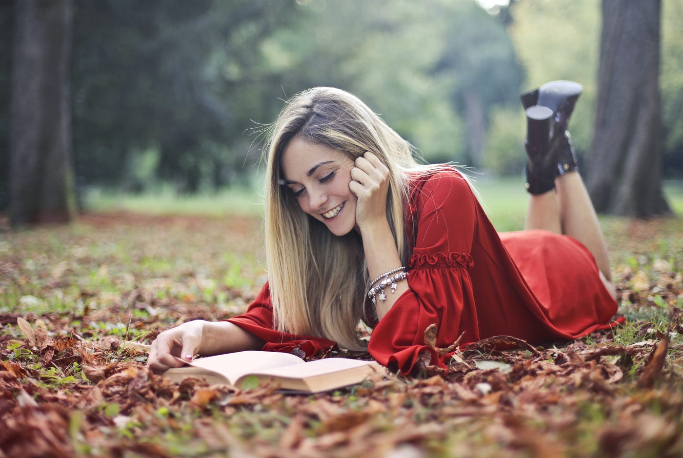 Girl reading a book in the leaves
