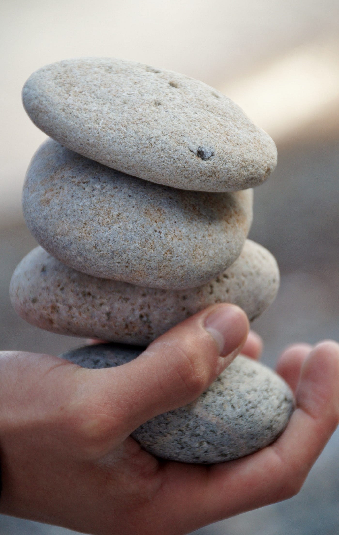 hand holding four stones