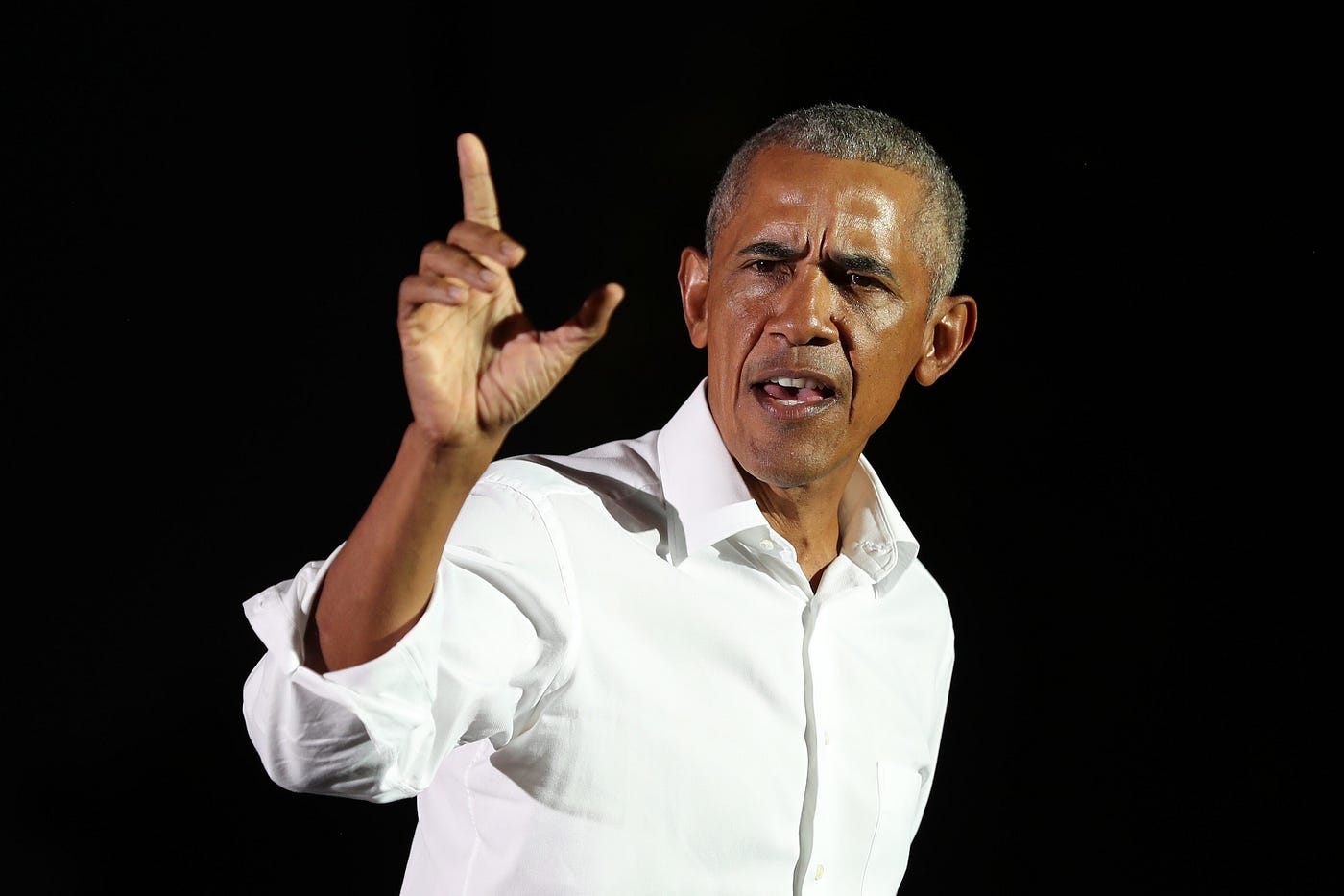 Former President Obama speaking against a black background.