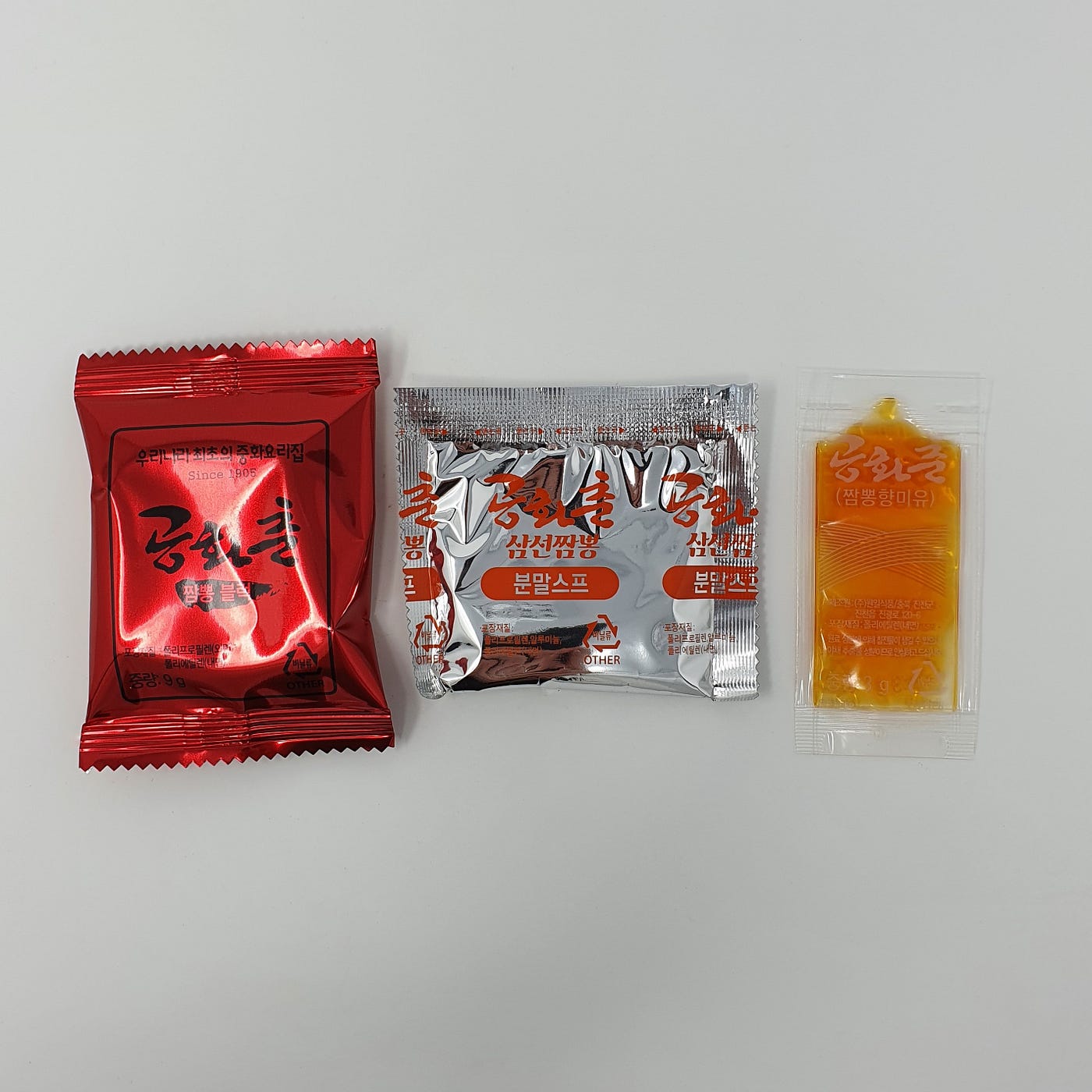 The three packets found inside a cup of YouUs Gonghwachun Samseon Jjambbong Instant Noodles.