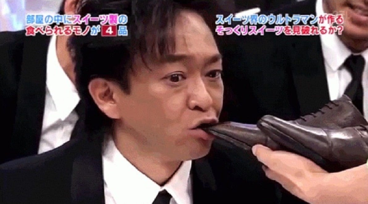 A man is biting a pair of shoes in the game of Candy or Not Candy