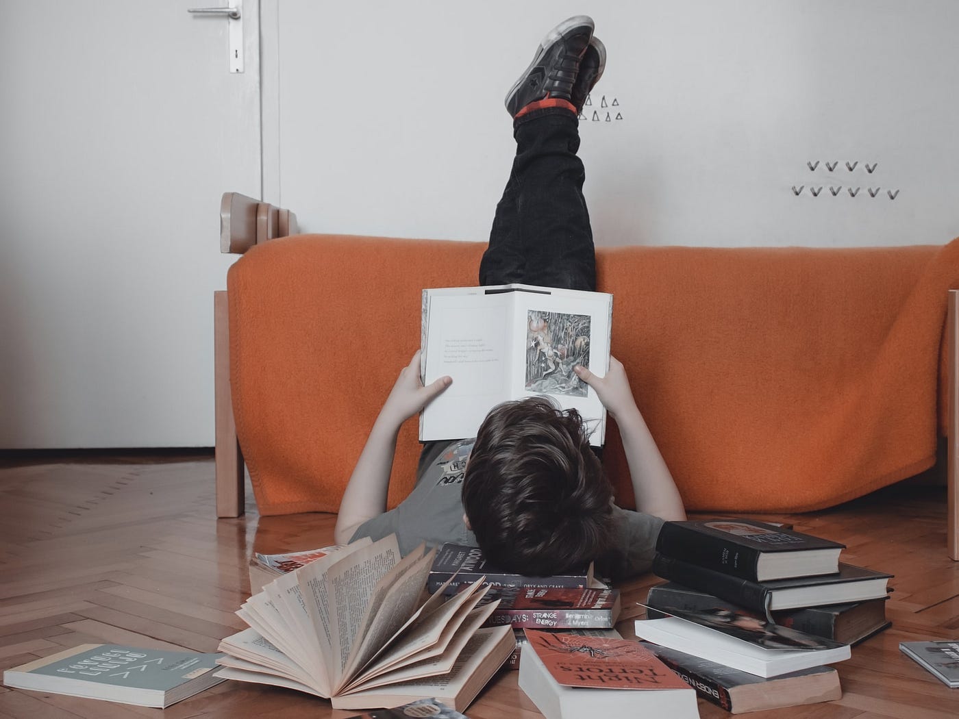 Woman reading books with feet up