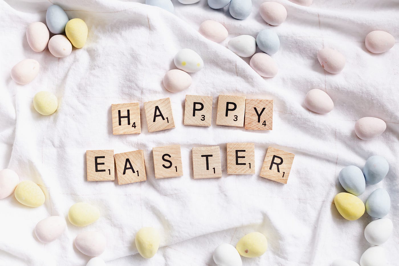 easter eggs on white surface with letter blocks spelling ‘happy easter’