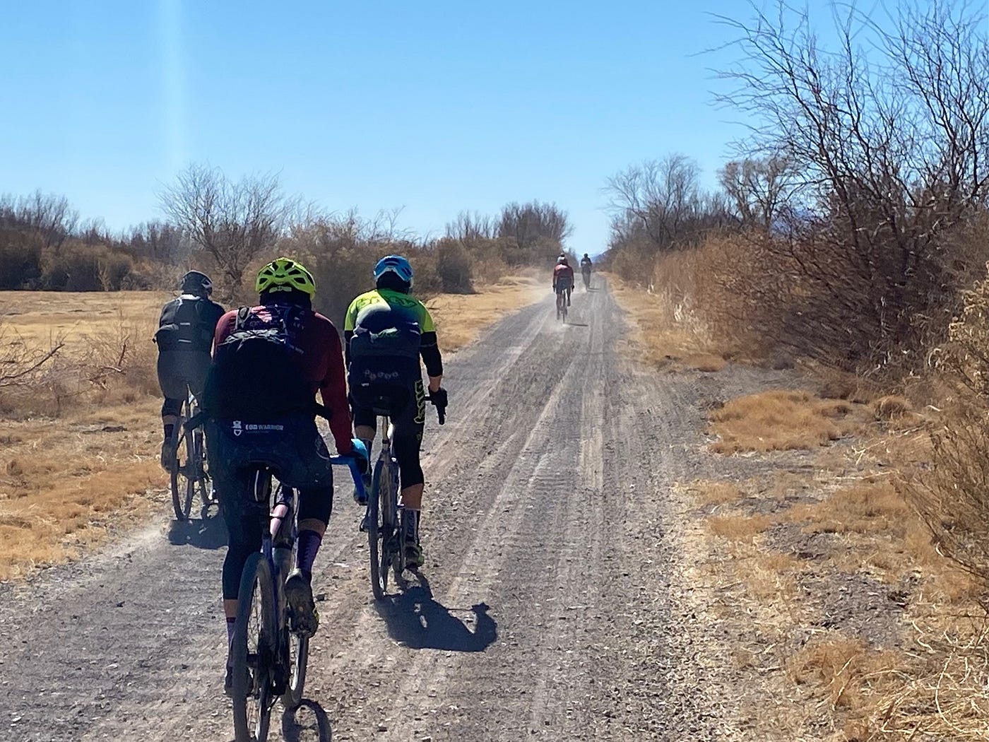 Five bike riders riding on a trail in the desert