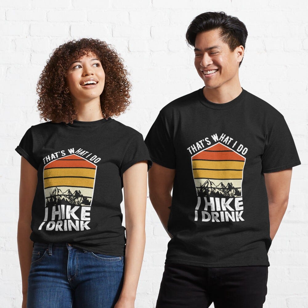 Man and Woman Wearing a black classic t-shirt with amazing illustration and text saying “that’s what I do I hike I drink”.