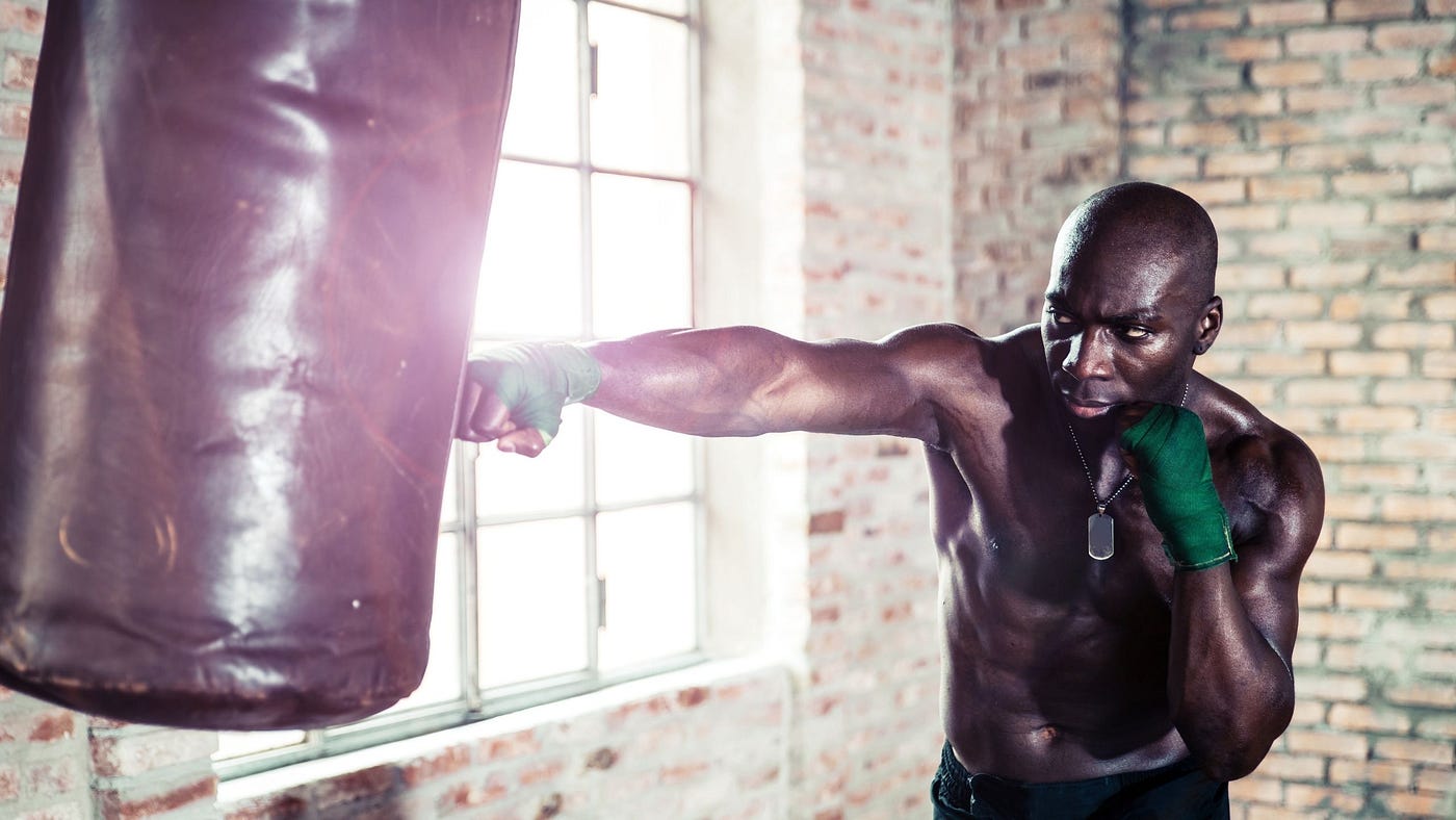 man hitting heavy bag