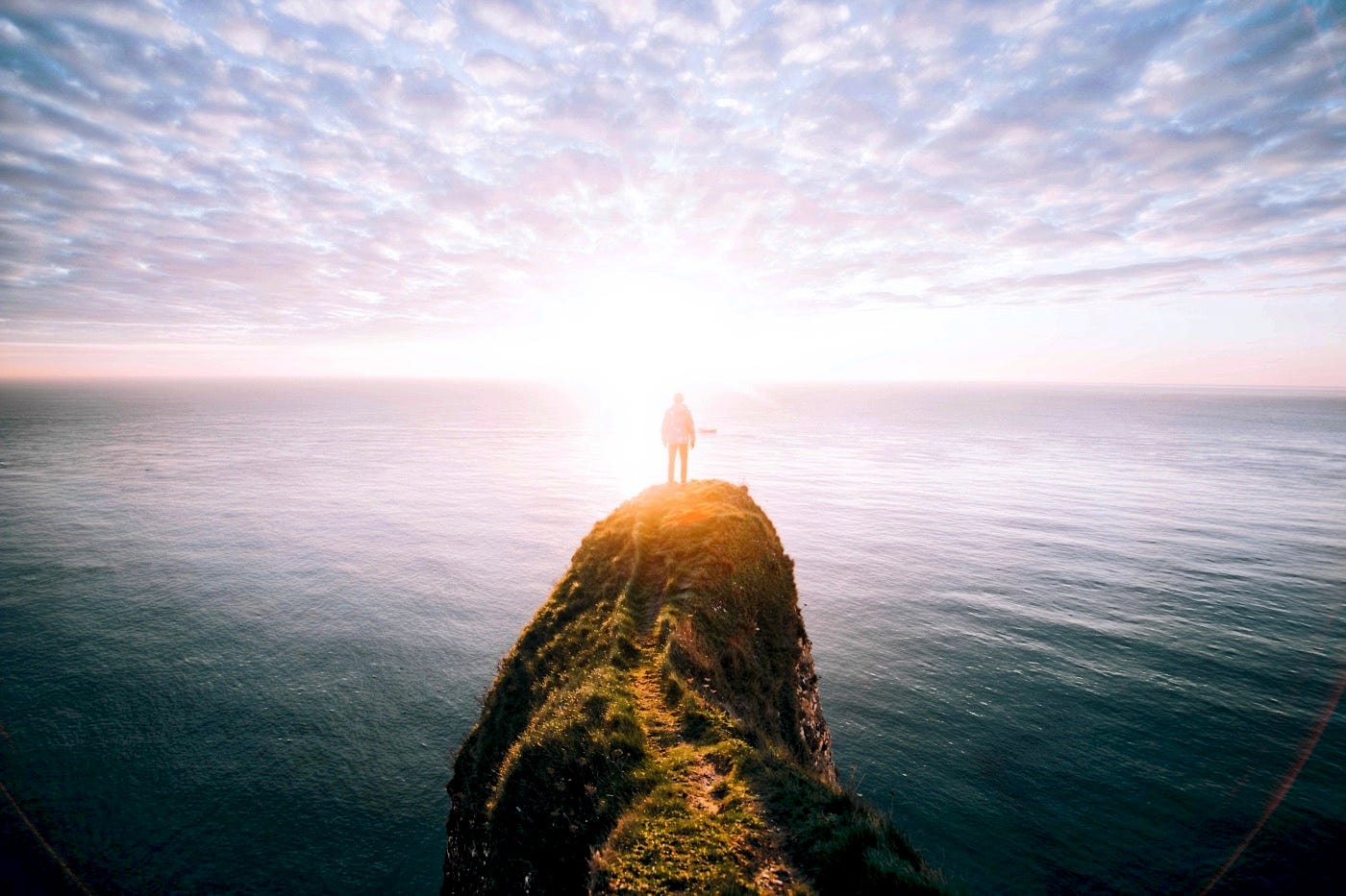 A man staring the sea horizon from a cliff