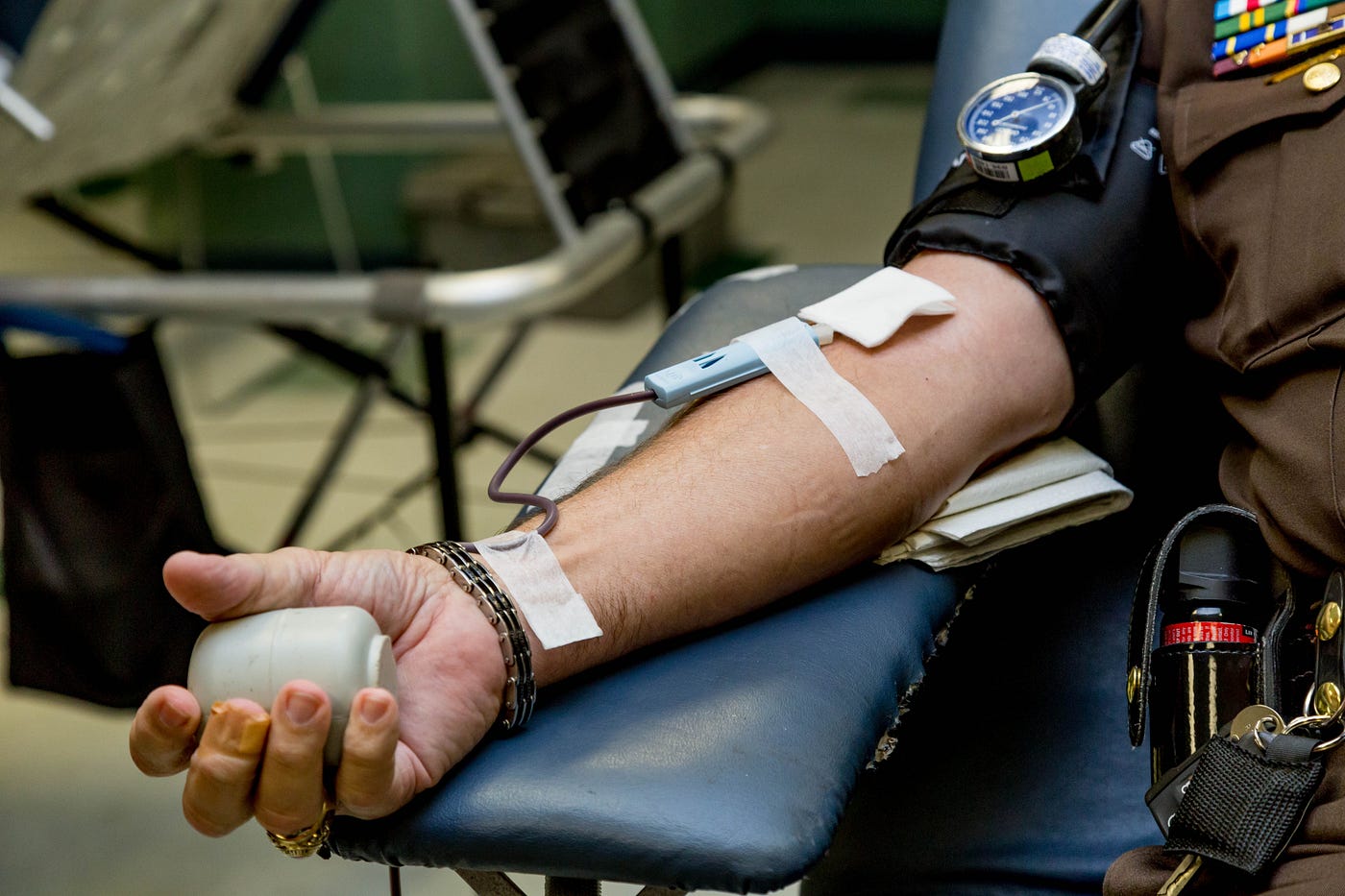 arm of light-skinned person in chair donating blood