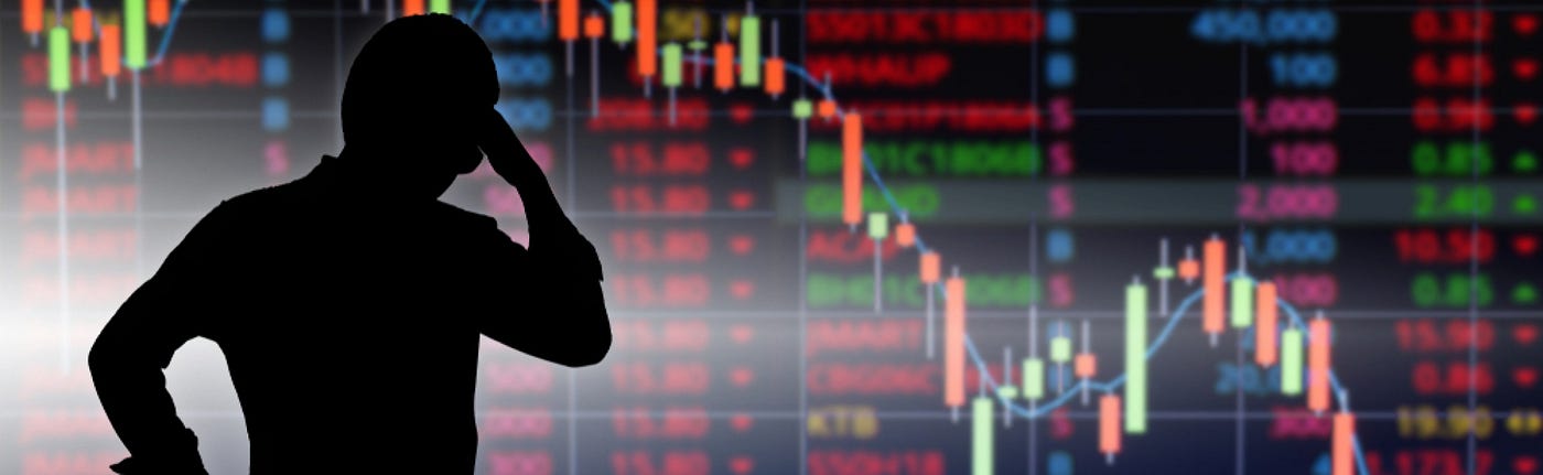 A Wall Street trader looks at a monitor showing the stock market index going down because of the coronavirus pandemic