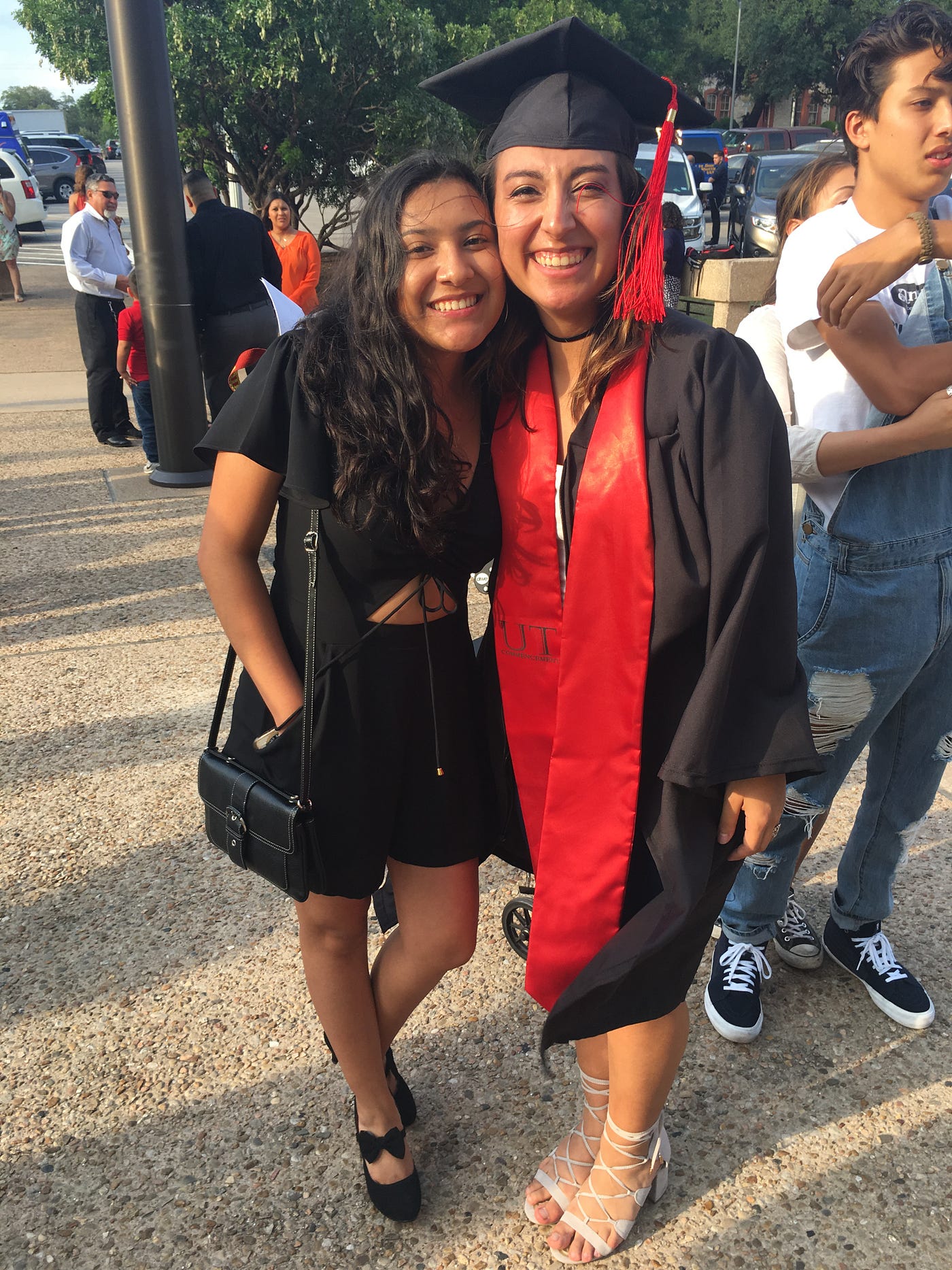 Josefina Mancilla, a Latina, in her college graduation cap and gown, embracing her sister for a picture.