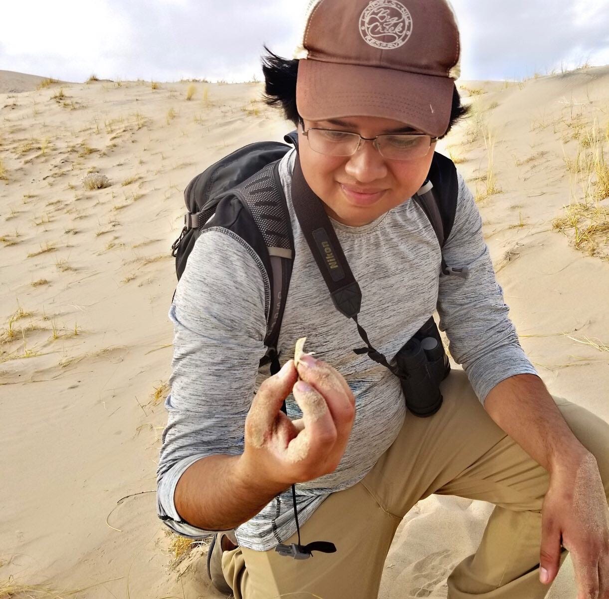 Kevin holds a baby lizard in the sand dunes