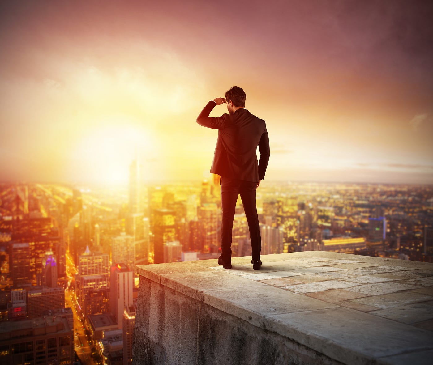Business guy on top of a building looking into the sunset