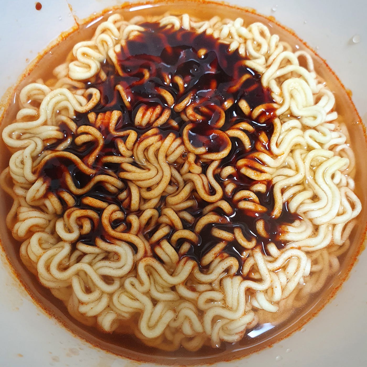 Boiling water filled up to the fill line in a cup of Samyang Buldalk Bokkeum Myeon Jjolbokki.