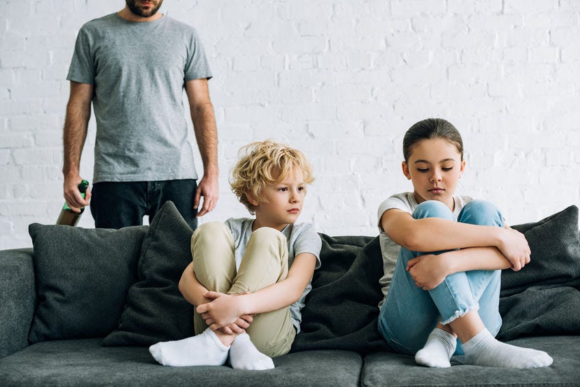 kids on couch with adult male in background