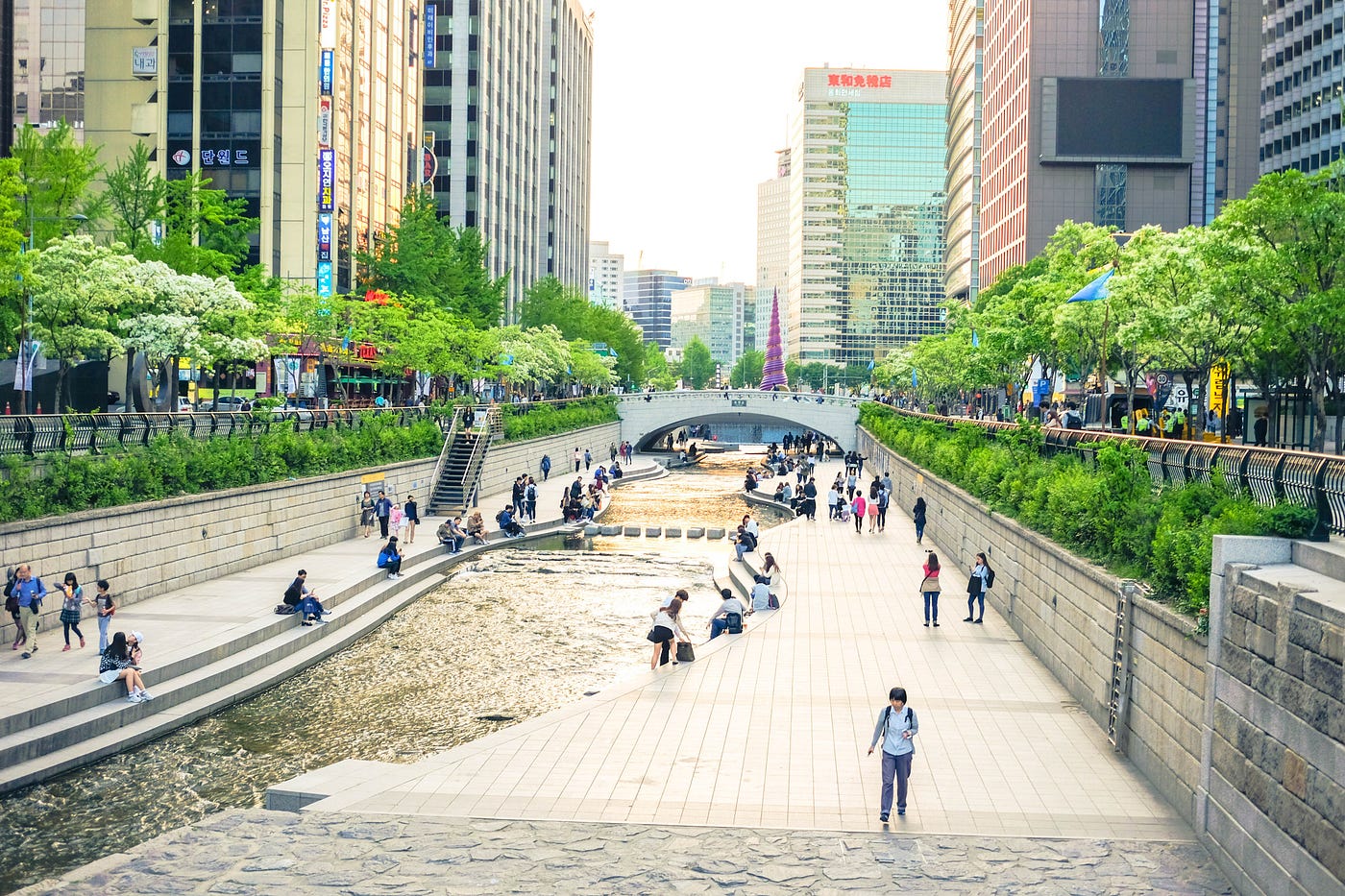 A reconstructed canal in the middle of the city of Seoul in South Korea where people are relaxing after a long day of work
