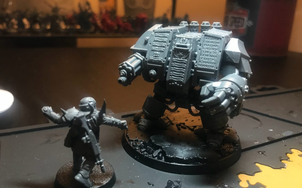 an unpainted miniature dreadnaught confronting a soldier
