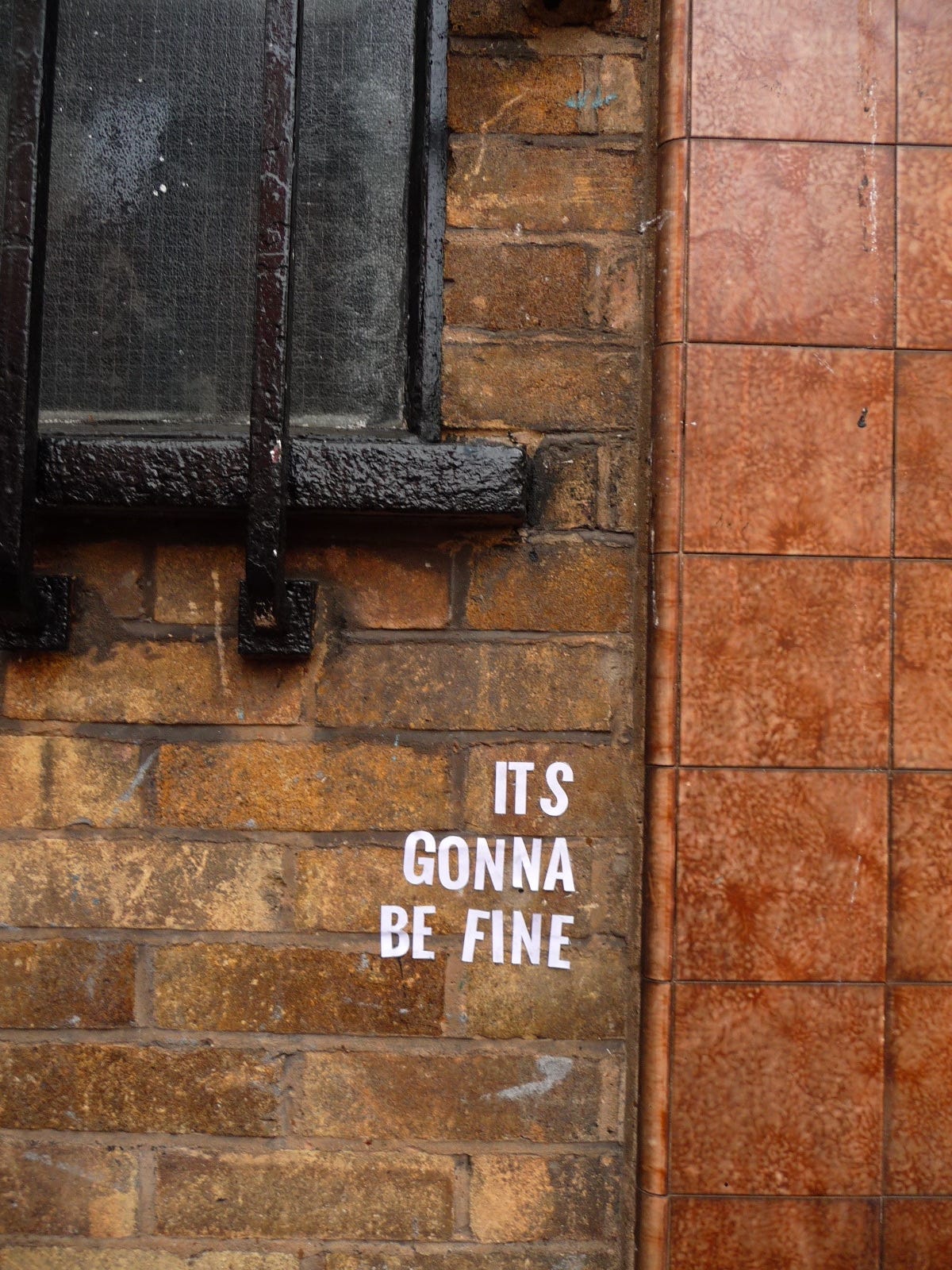 The words “It’s Gonna Be Fine” glued on a brick wall
