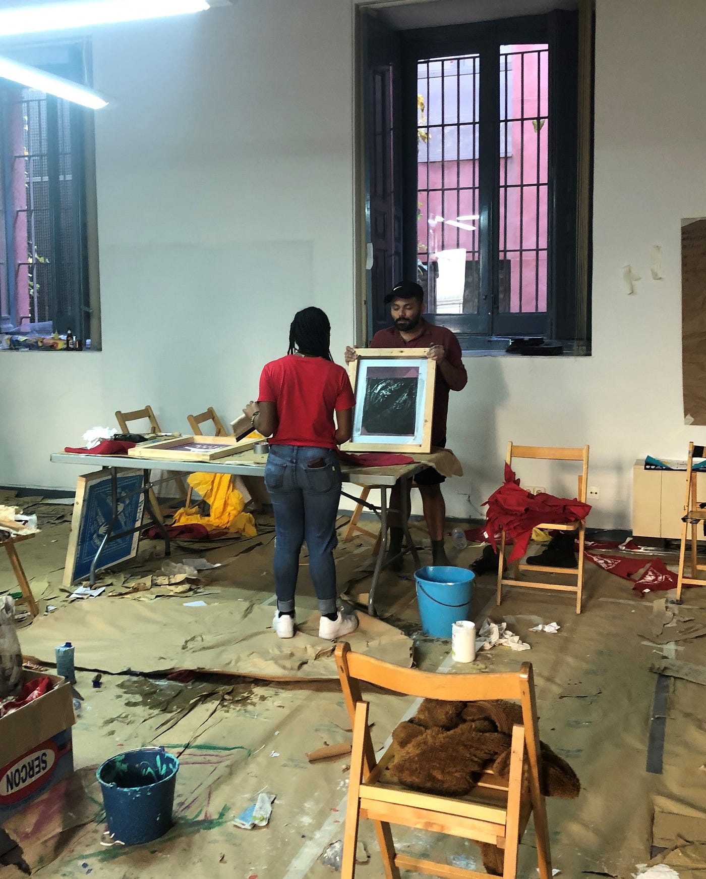 Two activists, Nyiesha and Carlos, creating protest art in a workshop