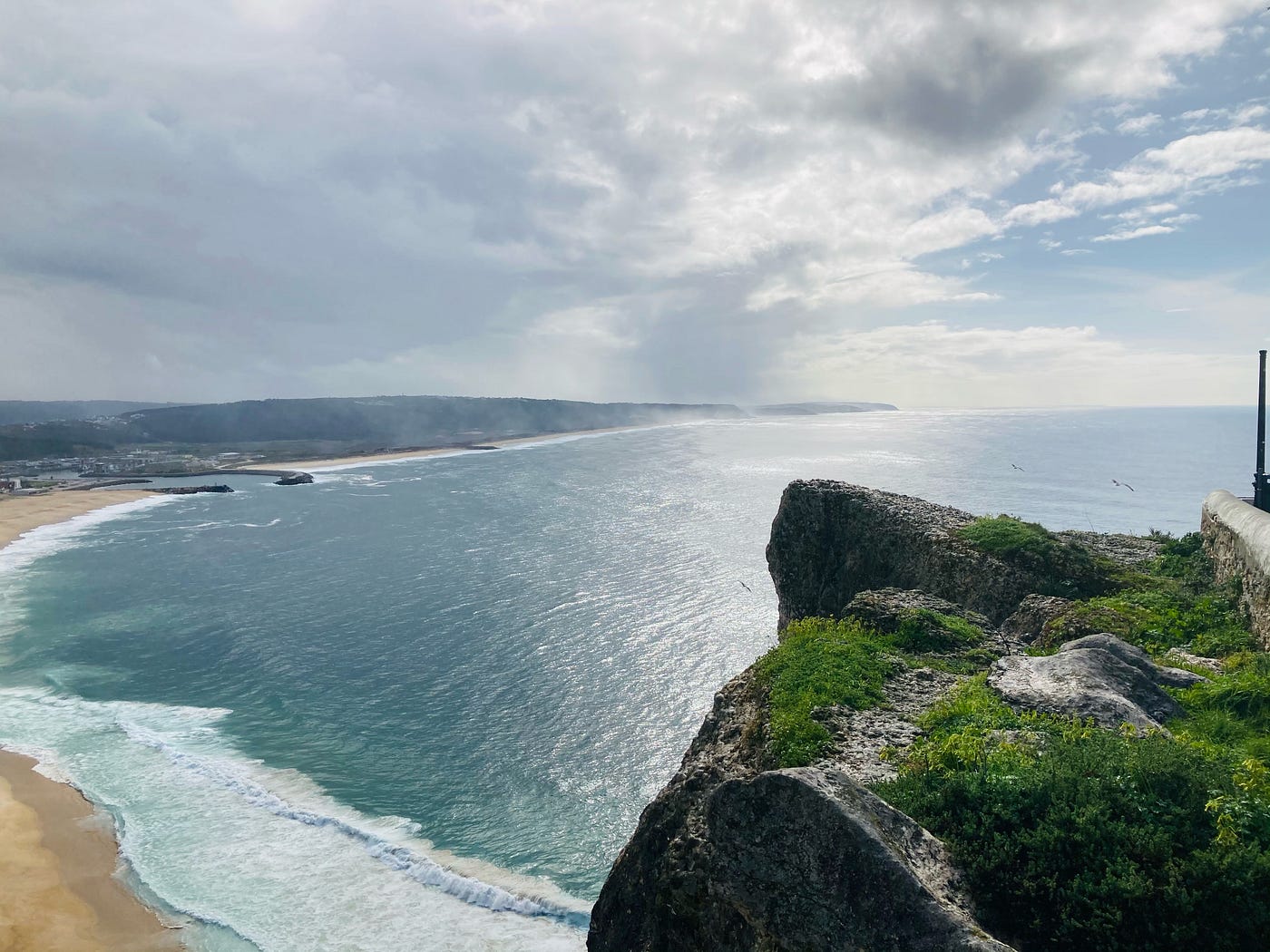 this is a view from a cliff at the beach in Nazaré, Portugal