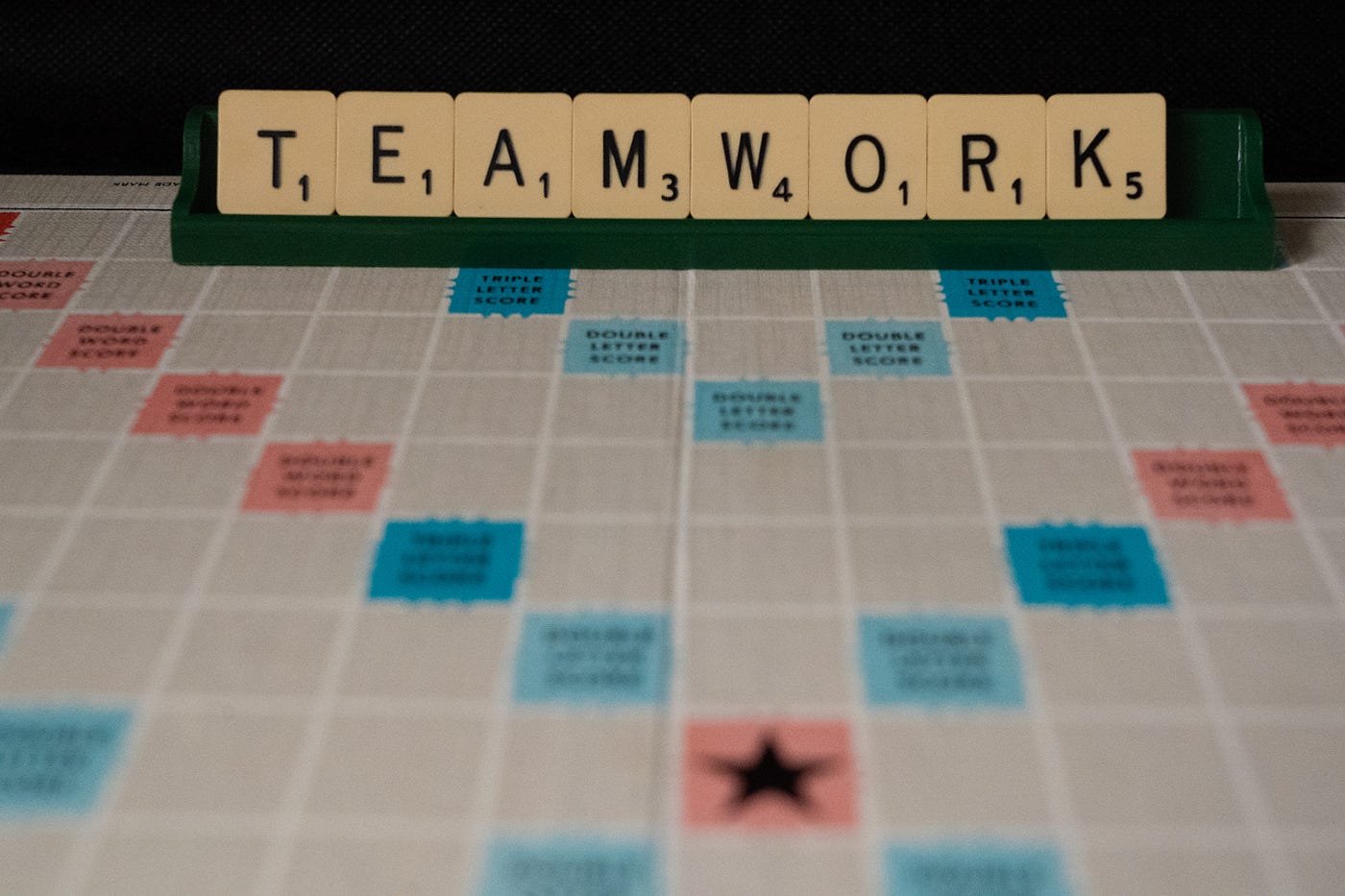 scrabble board showing “teamwork” in letter tiles