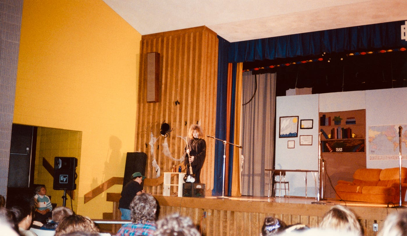 Photo of the author on stage alone dressed as a witch singing