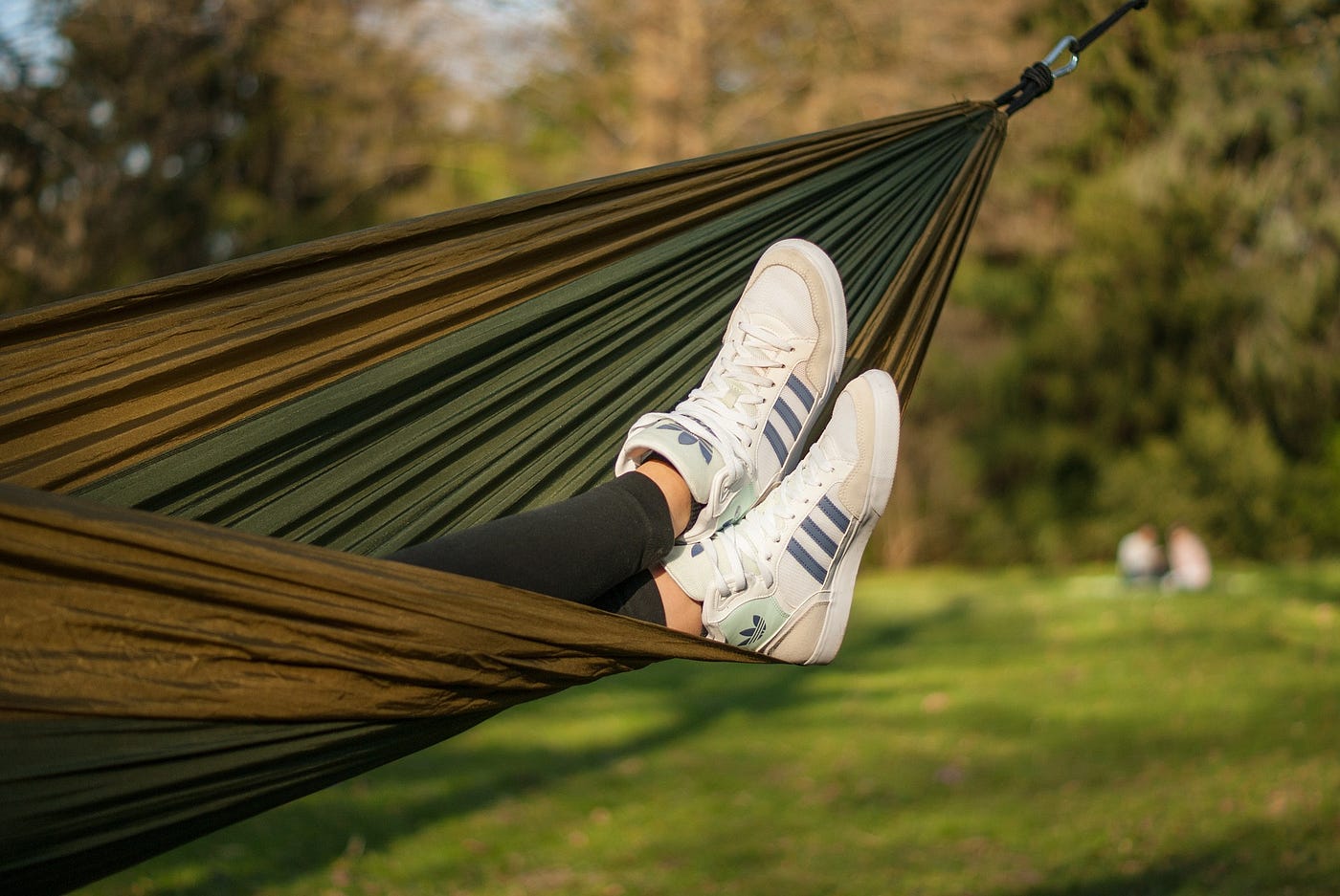 Person reclining on hammock.