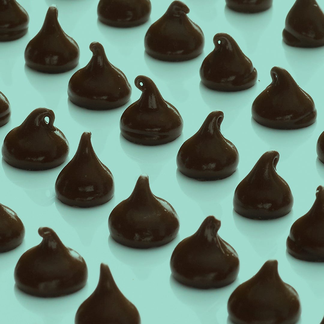 Chocolate chips arranged in rows on a green background