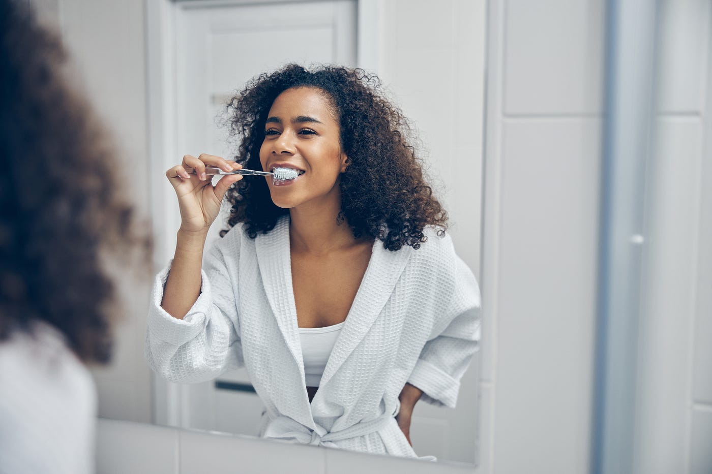 Image of woman brushing her teeth.