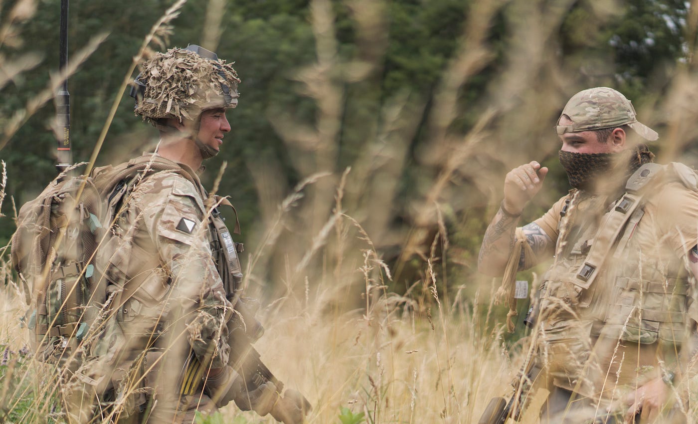British soldier engages with a local during a local leader engagement (simulated scenario using actors).