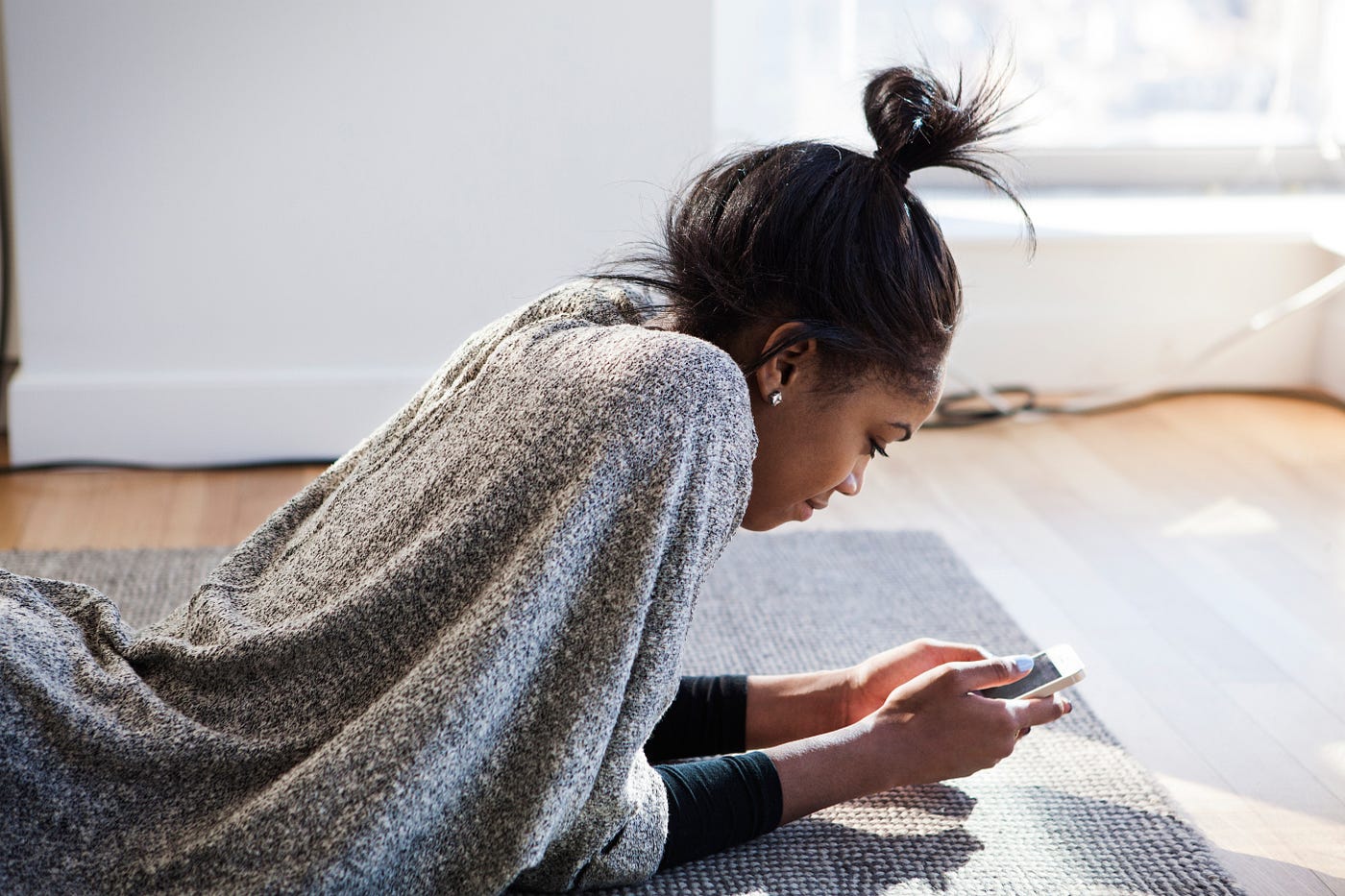 Young Black woman looking at her phone.