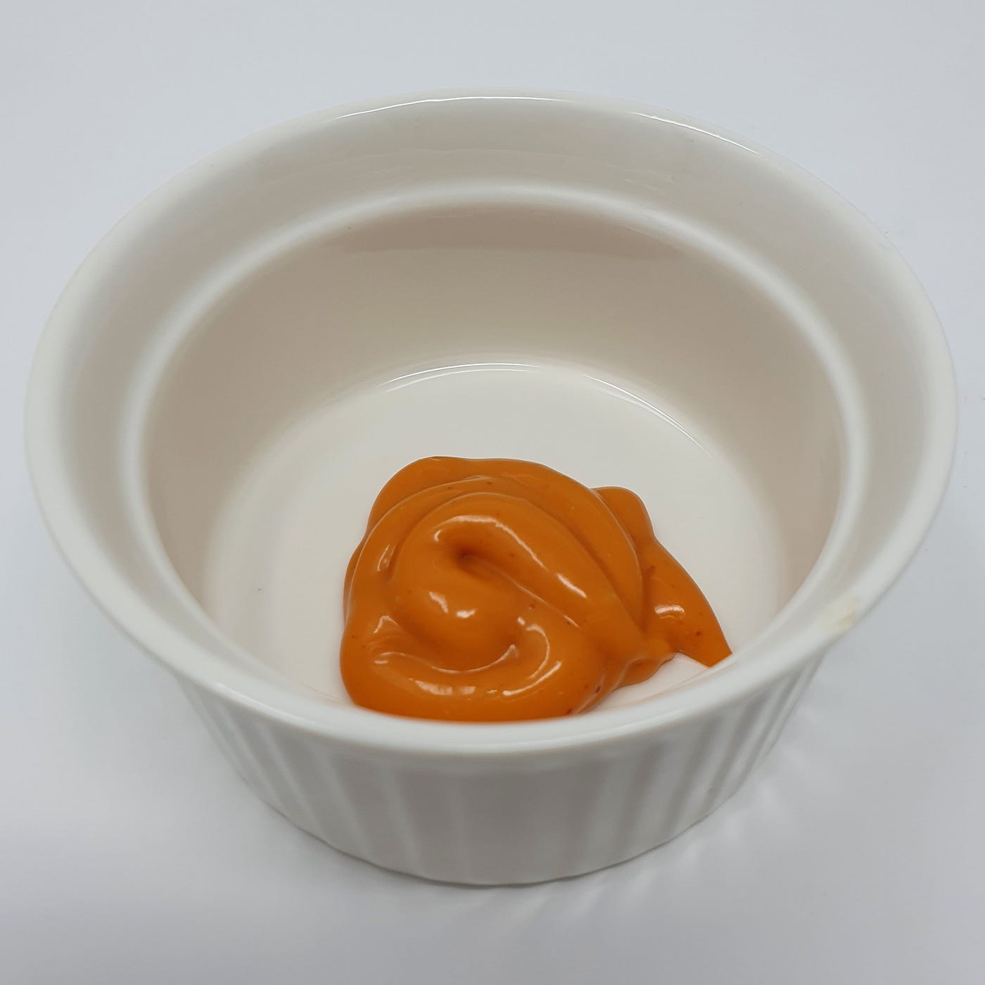 Samyang Buldalk Mayo in a small cup for use as a dip.