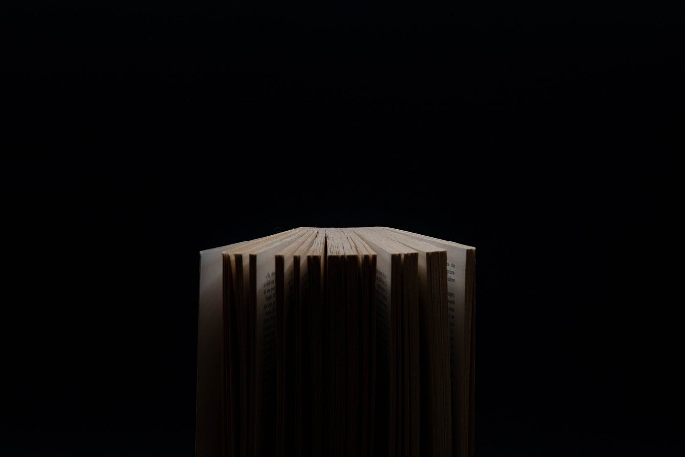 An open novel in a black space.