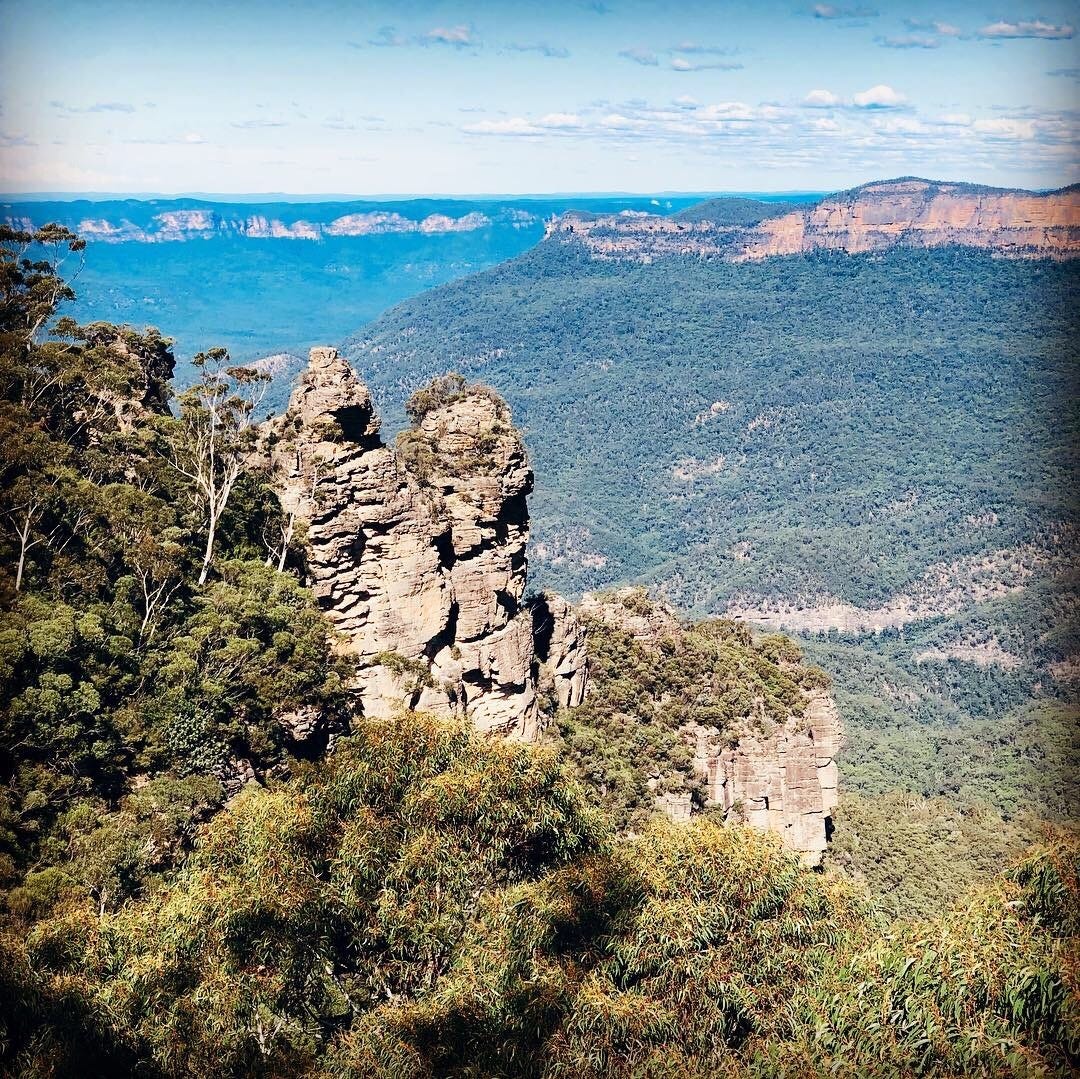 View of the valley in the blue mountains in Australia with the three sisters rock formation in the foreground.
