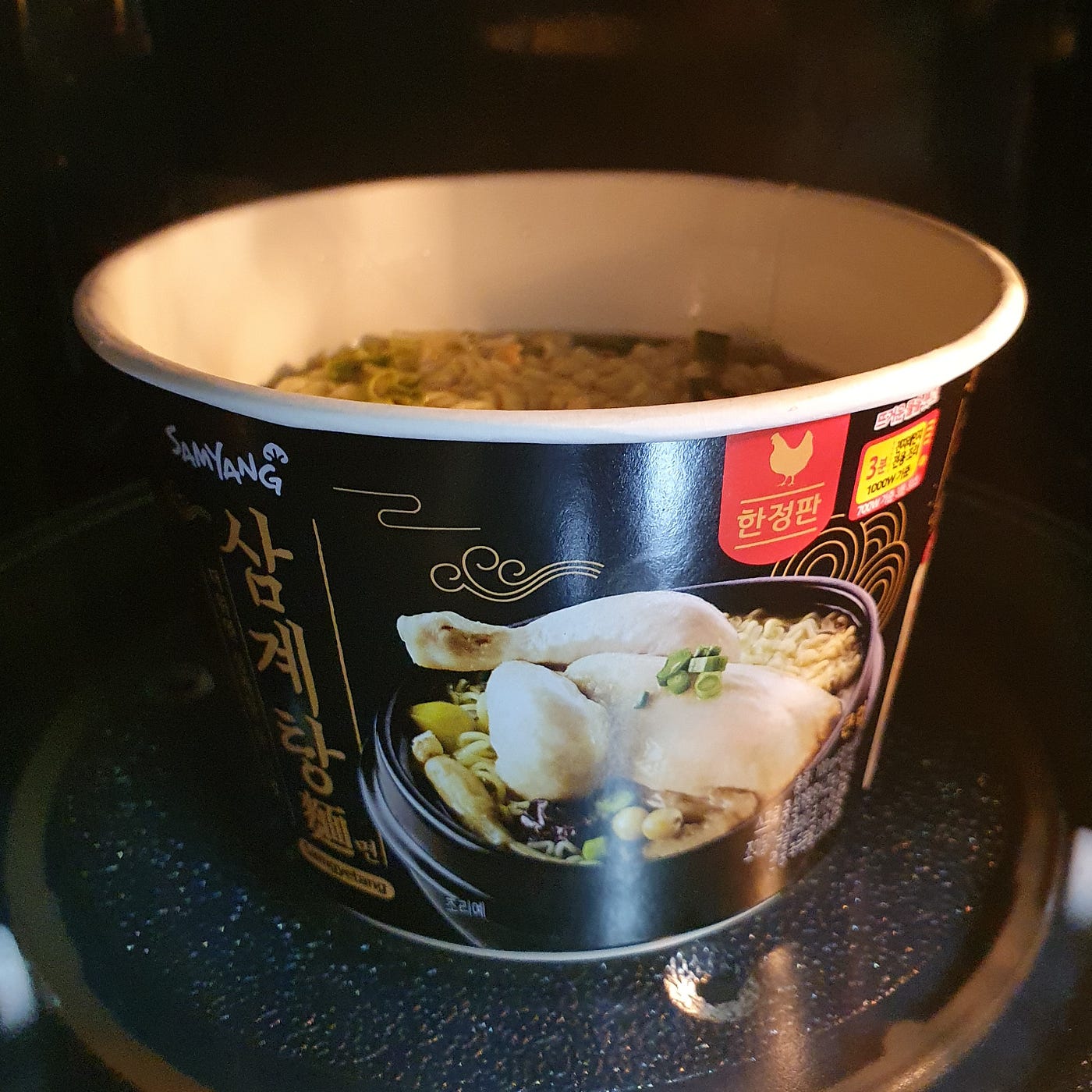 Cooking a cup of Samyang Samgyetang Myeon Instant Noodles in the microwave for 3 minutes and 30 seconds at 700 watts.