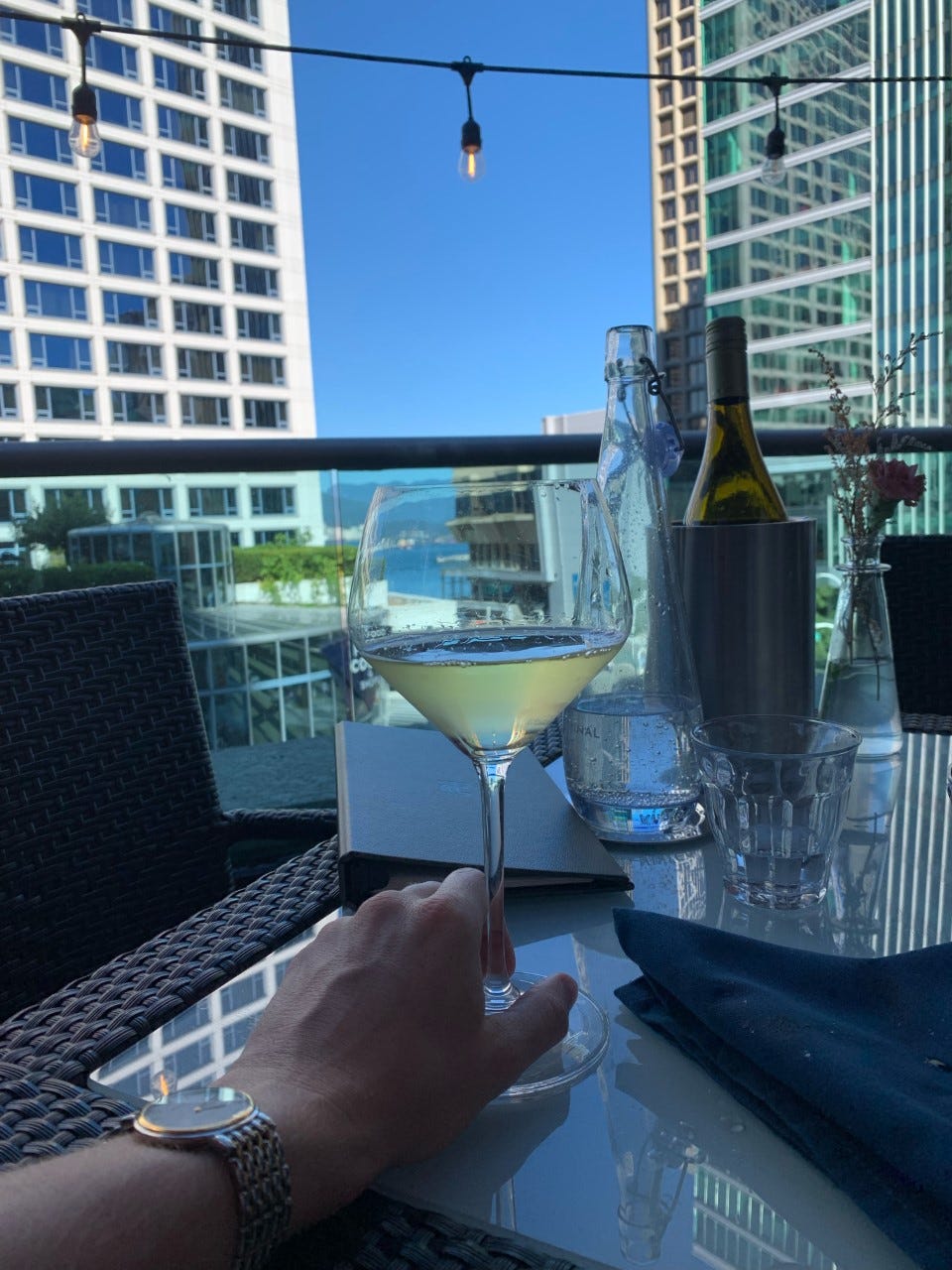 A glass of buttery chardonnay on a rooftop patio.