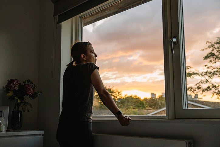 A woman looking out of the window at the sunset