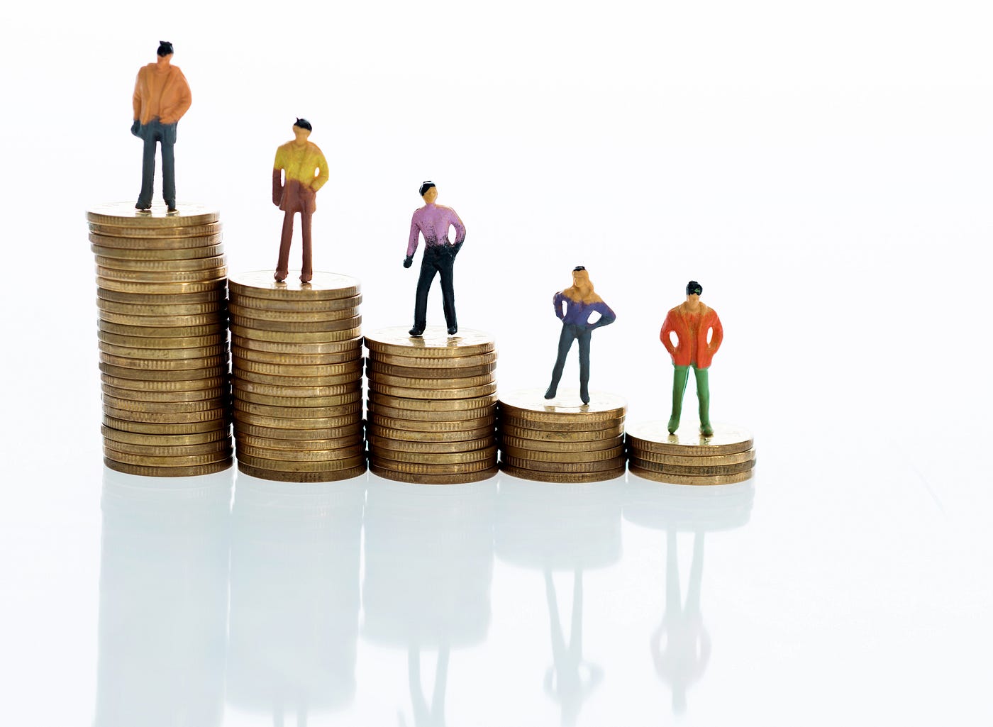 Figurines standing on stack of coins