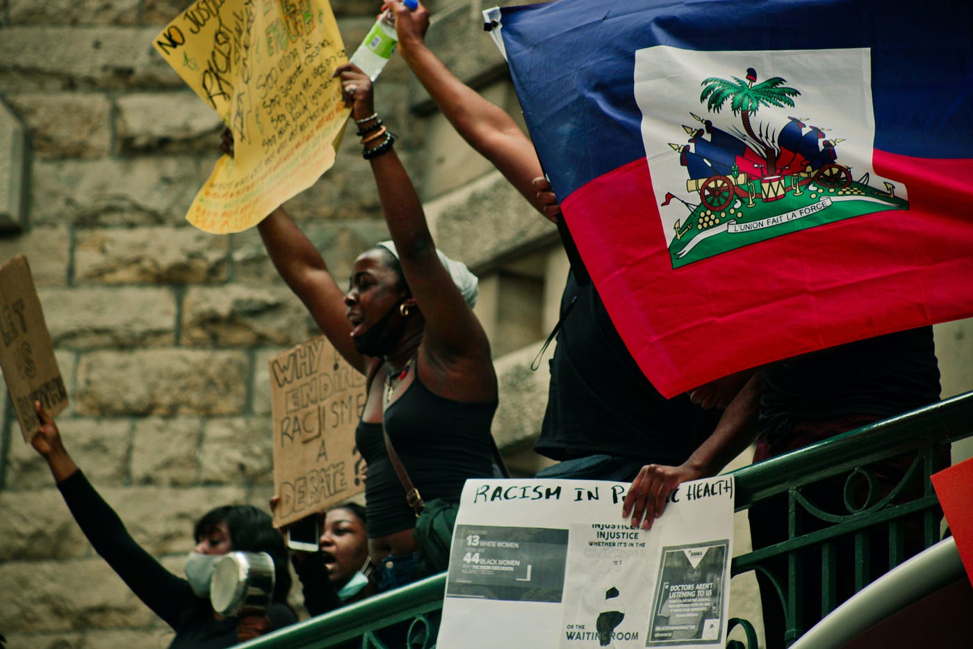 Black people protesting and Haitian flag