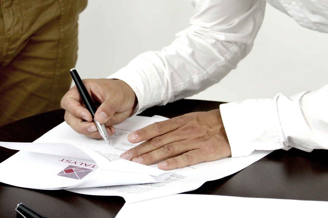 man signing document