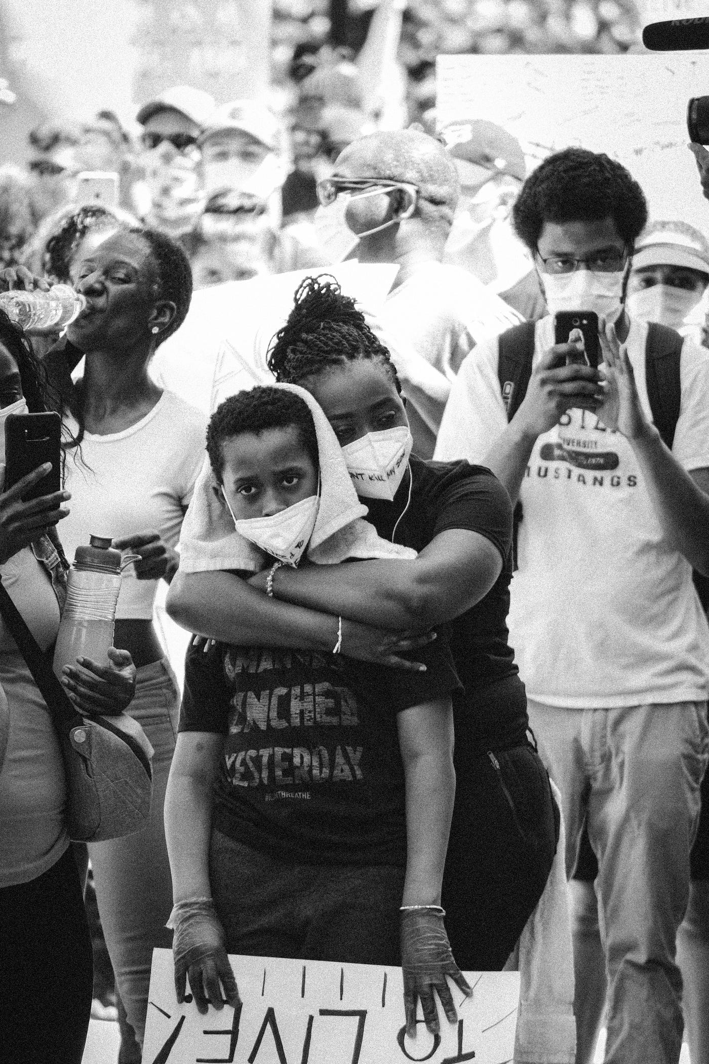 Black Lives Matter protest with mother hugging her child.