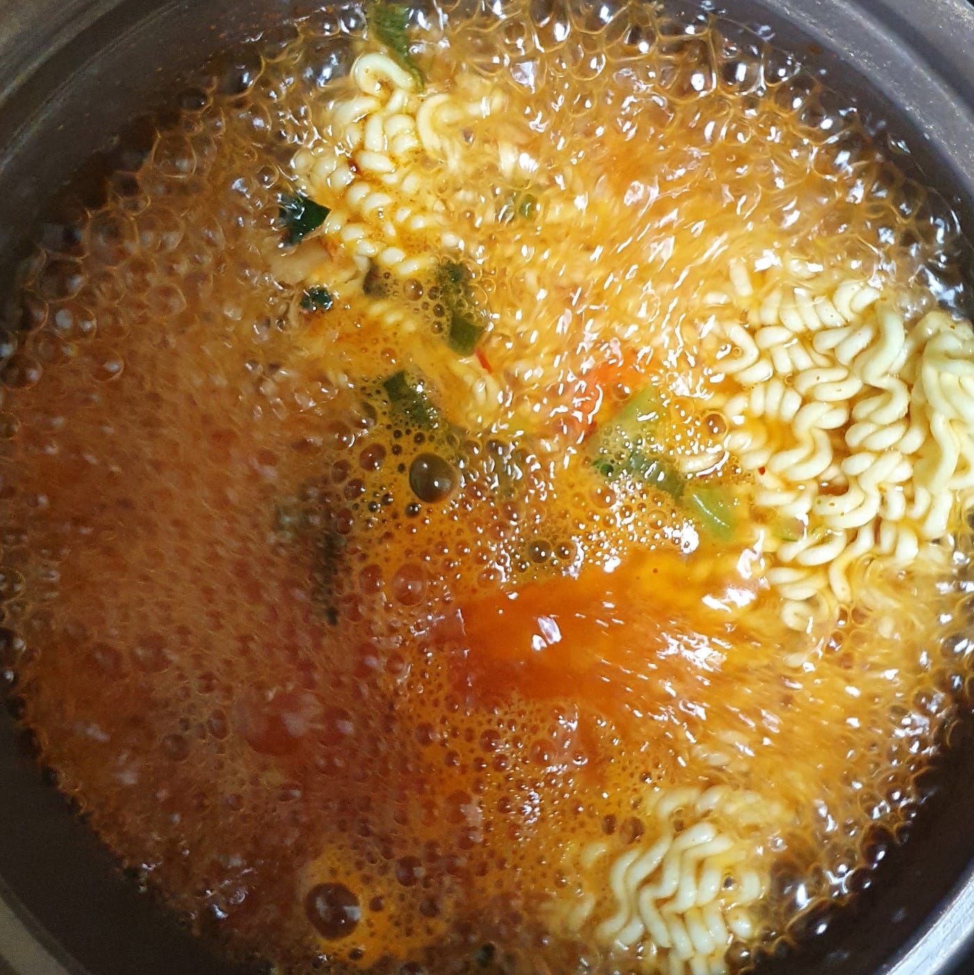 Cooking the ingredients for a bowl of Ottogi Yeol Ramen for 4 minutes in a pot.